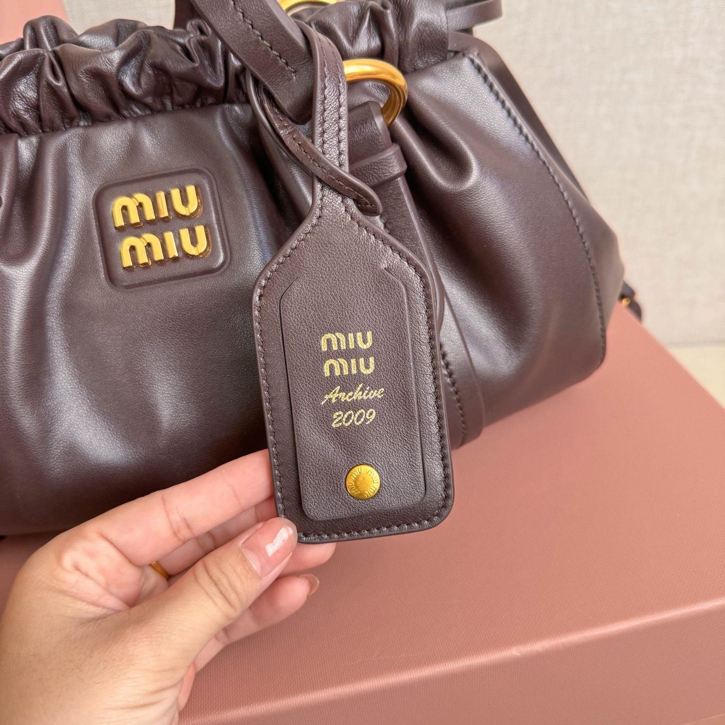 MIU中古腋下饺子包，全新植柔羊皮满满复古怀旧风情，搭配钢质做旧金属五金配件，质感高级典雅，袋口采用抽绳束口设计，细密的皱褶花边立体而俏皮，高级又不失慵懒随性，内搭全新条纹帆布里，配一个拉链隔层，独特的设计谁用谁好看