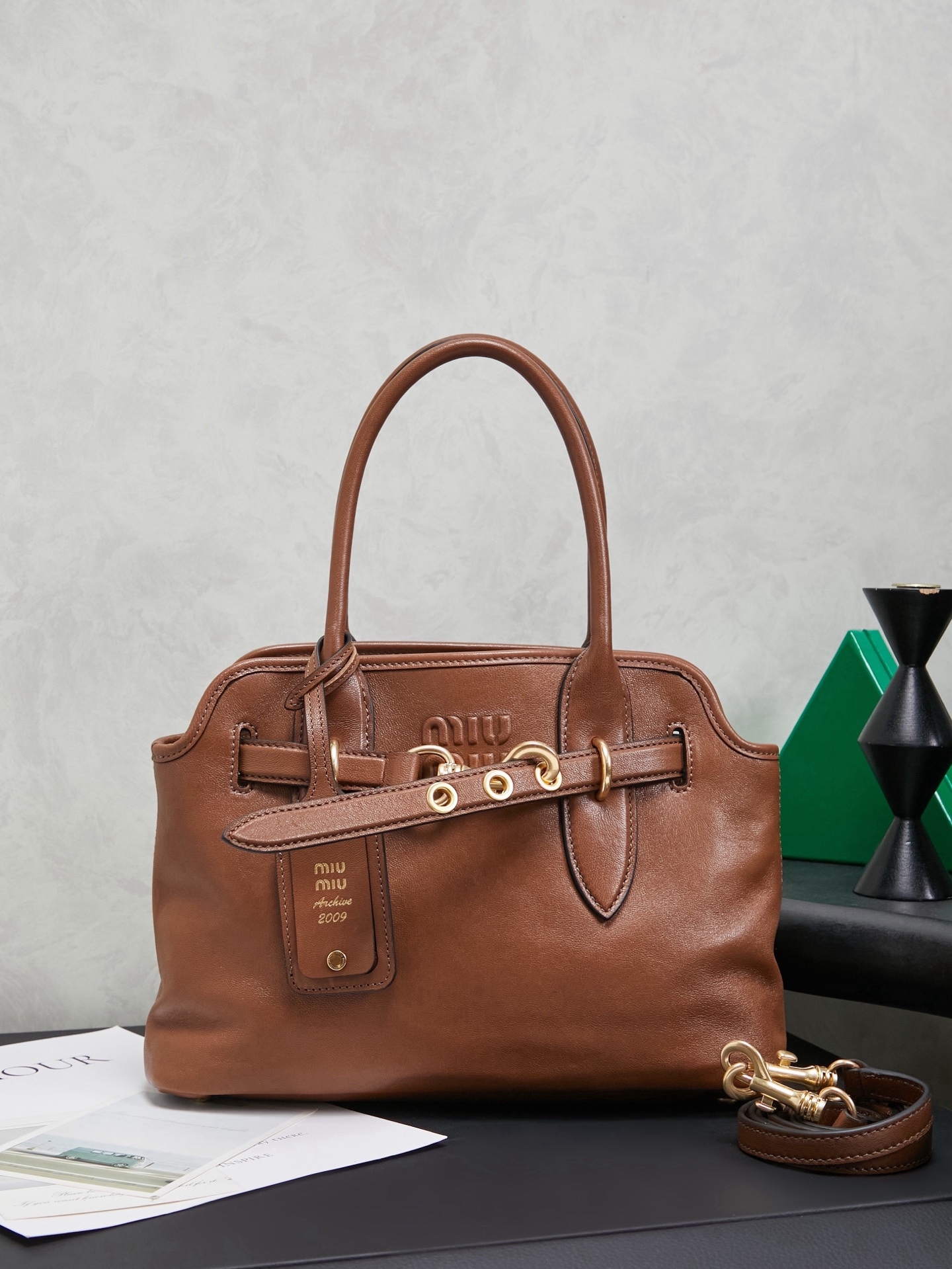 Aventure包袋展现出简约随性的魅力。重新诠释经典线条，这款柔软的Nappa变体展现出多功能和实用的态度，并通过精致独特的细节得到提升。aventure nappa皮革手袋灵感源自miu典藏设计，结构经过调整，变得更加轻便，焕发全新个性，饰以压花字母徽标，增添标志性元素，复古金色五金配件，亚麻混纺衬里，配拉链口袋和贴袋，长手腕适合用作手提或单肩
