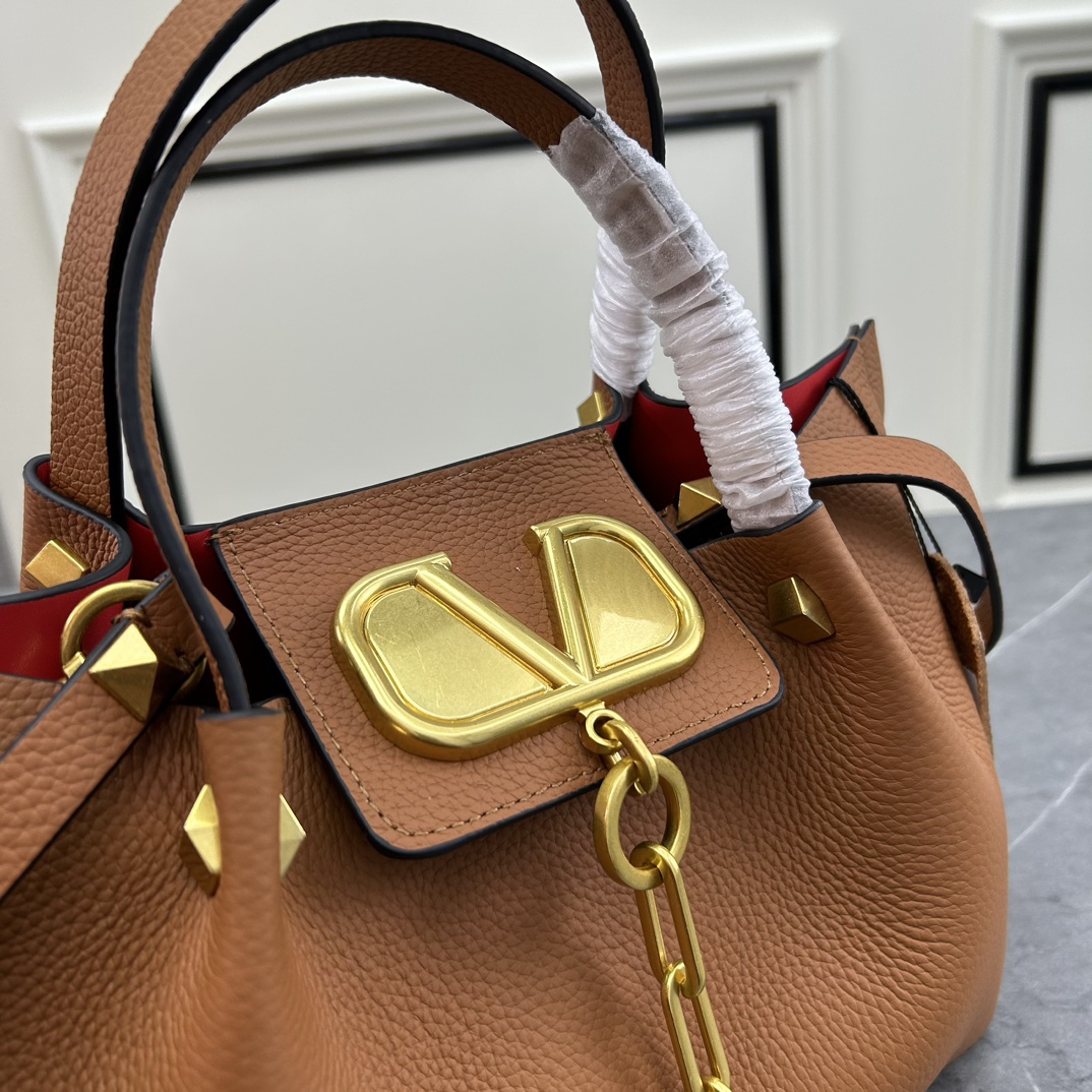 荔枝紋 Garavani VLOGO Escape 小牛皮小號購物袋，包袋兩側點綴紅色細節，金屬徽標飾件可用在包裝內部作為開合，亦可用在外部作為裝飾元素。
小號尺寸：31 *25*15 cm