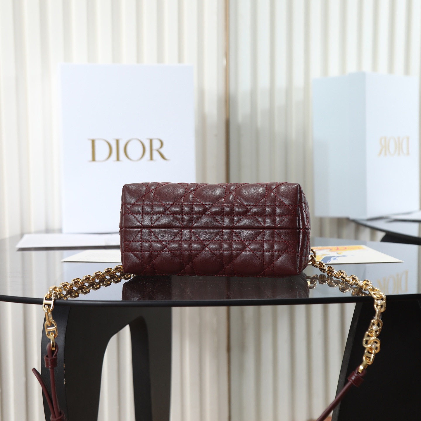 原廠級 酒紅色鏈條手袋
這款 Dior Jolie Top Handle 迷你鏈條手袋是二零二六早春成衣系列新品，呈現出優雅精緻的設計。採用黑色羊皮革精心製作，飾以藤格紋，翻蓋點綴以金色飾面金屬 CD 標誌和白色樹脂珠飾。內設一個隔層，可收納各種日常用品。搭配雙頂部手柄和可調節、可拆卸 CD 鏈條肩帶，肩帶由皮革帶和 CD 鏈環組成，飾以白色樹脂珠飾，可舒適手提、肩背或斜挎，可與日常或晚裝造型搭配。

