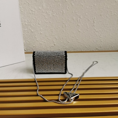 【 原單】🎉項鍊水晶小包🎉1MR024新色🎉🎉這款Duchesse面料卡片夾通體飾以仿水晶，於表面營造出光影格調和虹彩炫色，彰顯華美且不失功能性的設計。最愛是這條可拆卸可調節鐵璉肩帶，又可當腰包裝飾😍😍又可當搭配衣服項鍊裝飾，中間三角形標可調節活動，賦予單品多樣的佩戴方式。空間可裝口紅💄/耳機/鑰匙🚗....夜燈下bling bling,太美了。值得入手🎉🎉尺寸：長11.5cm*高8cm