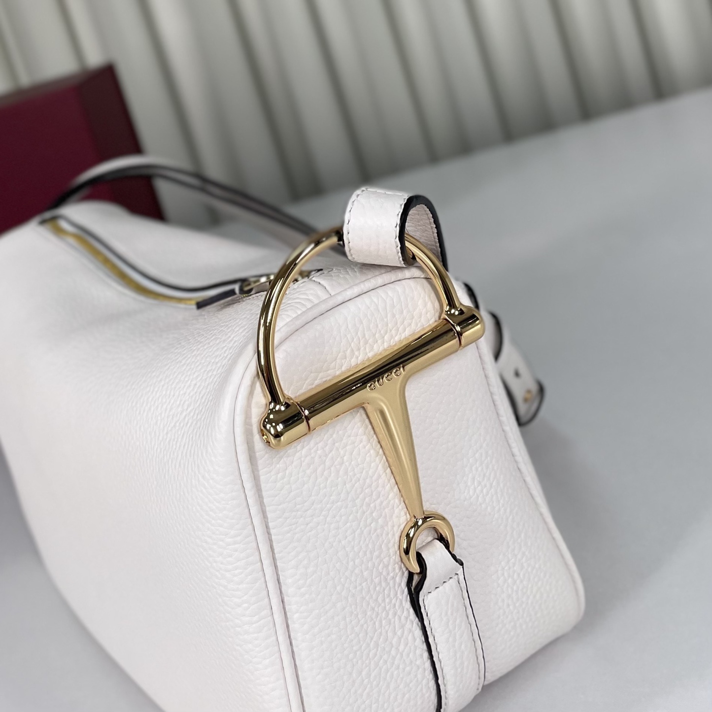 Gucci Half Horsebit系列中號肩背包，煥新呈現Gucci Half Horsebit系列，以現代風格煥新演繹品牌最具標誌性的元素之一。該系列巧妙融蘊休閒廓形與標誌性的半馬銜扣配件，這也是其名稱的由來。款號860787白皮，尺寸31.5X17X12