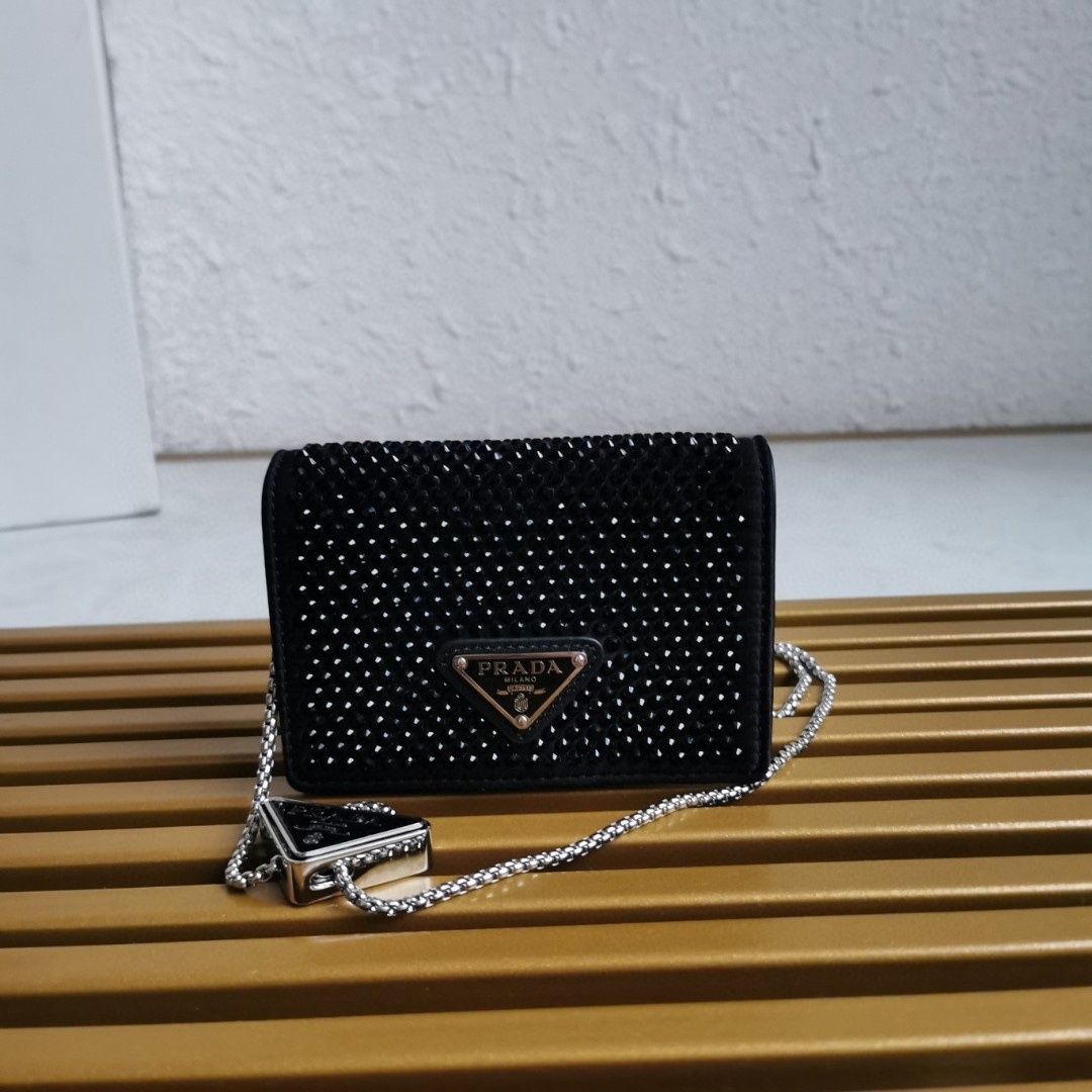 【 原單】🎉項鍊水晶小包🎉1MR024新色🎉🎉這款Duchesse面料卡片夾通體飾以仿水晶，於表面營造出光影格調和虹彩炫色，彰顯華美且不失功能性的設計。最愛是這條可拆卸可調節鐵璉肩帶，又可當腰包裝飾😍😍又可當搭配衣服項鍊裝飾，中間三角形標可調節活動，賦予單品多樣的佩戴方式。空間可裝口紅💄/耳機/鑰匙🚗....夜燈下bling bling,太美了。值得入手🎉🎉尺寸：長11.5cm*高8cm