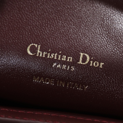 原廠級 酒紅色鏈條手袋
這款 Dior Jolie Top Handle 迷你鏈條手袋是二零二六早春成衣系列新品，呈現出優雅精緻的設計。採用黑色羊皮革精心製作，飾以藤格紋，翻蓋點綴以金色飾面金屬 CD 標誌和白色樹脂珠飾。內設一個隔層，可收納各種日常用品。搭配雙頂部手柄和可調節、可拆卸 CD 鏈條肩帶，肩帶由皮革帶和 CD 鏈環組成，飾以白色樹脂珠飾，可舒適手提、肩背或斜挎，可與日常或晚裝造型搭配。
