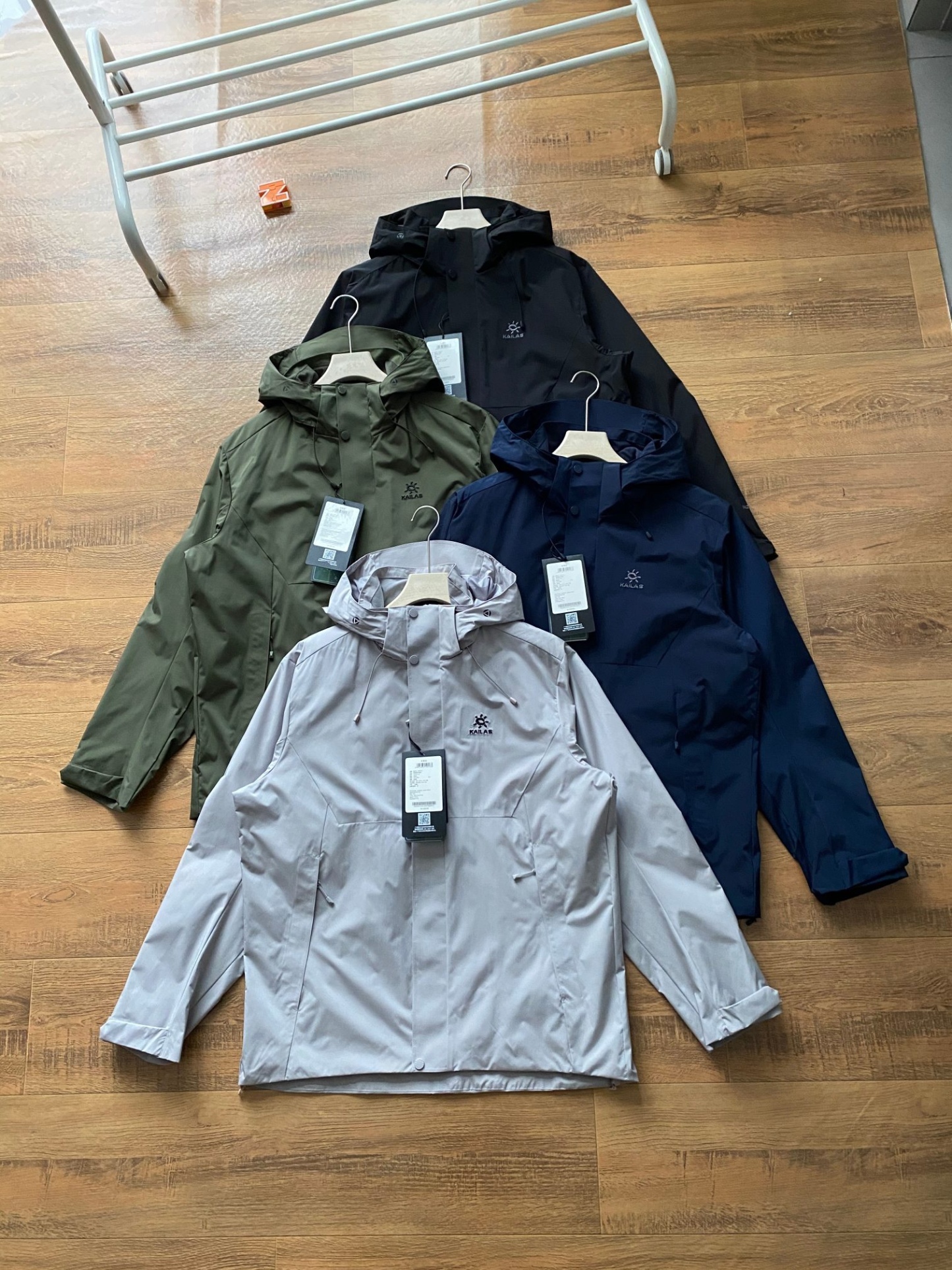 新款連帽三色風衣凱樂石KALIAS春季男子速乾輕薄外套 它的連帽設計，不僅時尚，還能在多變天氣中為你遮風擋雨。精選優質面料，觸感舒適，穿著自在無束縛，且具備良好的透氣性與耐磨性，滿足你的各種活動需求。版型上，注重亞洲人體型特點，舒適百搭，可輕鬆搭配各類下裝。無論是搭配牛仔褲展現休閒風，還是搭配工裝褲凸顯硬朗氣質，都毫無壓力。細節之處盡顯品質，精緻的縫線工藝，耐用的拉鍊與扣件，每一處都經過精心考量，只為給你帶來極致的穿著體驗。真正的3D立體裁剪，袖口添加魔術貼可自由調節 真正做到貼合身材比例，