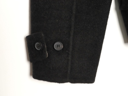 🔝BURBERRY巴寶莉BBR 雙面穿羊毛連帽外套
精選雙面羊毛斜紋面料，通過獨特的拉絨工藝處理，使表層呈現細膩豐盈的絨毛質感，觸感如雲朵般柔軟親膚，同時保留羊毛天然的保暖性與透氣性。一面以沈穩黑色演繹低調奢華，另一面則鋪滿標誌性的紅、黑、駝三色交織的經典圖案，既是品牌視覺符號，也為穿搭注入復古氣息。雙面可穿的設計，讓一件外套擁有兩種風格。
選用優質羊絨纖維進行精細紡紗，確保紗線的均勻性和強度。然後，通過先進的織造技術將紗線織成具有雙面效果的毛呢面料。
面料在裁剪前會經過預縮處理