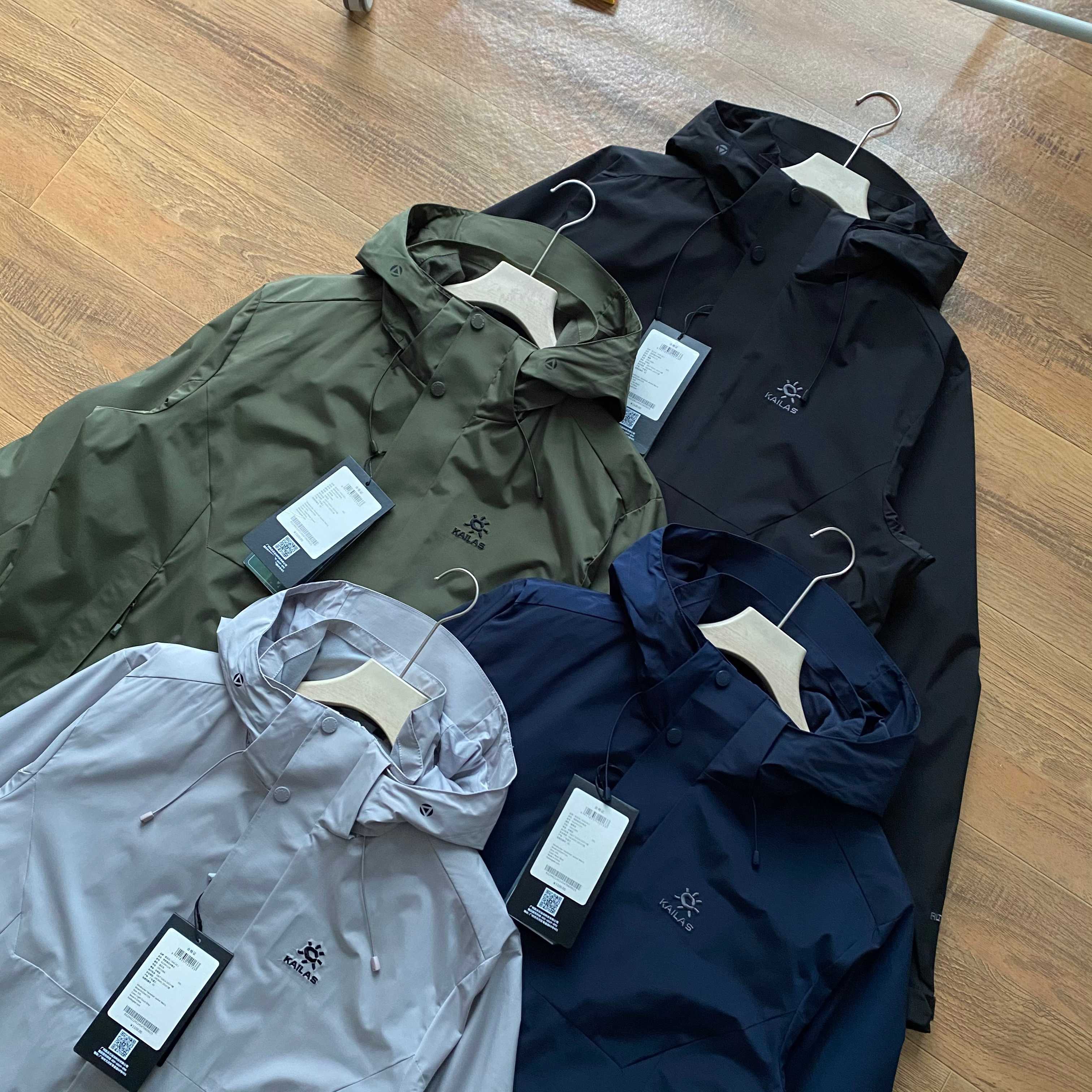 新款連帽三色風衣凱樂石KALIAS春季男子速乾輕薄外套 它的連帽設計，不僅時尚，還能在多變天氣中為你遮風擋雨。精選優質面料，觸感舒適，穿著自在無束縛，且具備良好的透氣性與耐磨性，滿足你的各種活動需求。版型上，注重亞洲人體型特點，舒適百搭，可輕鬆搭配各類下裝。無論是搭配牛仔褲展現休閒風，還是搭配工裝褲凸顯硬朗氣質，都毫無壓力。細節之處盡顯品質，精緻的縫線工藝，耐用的拉鍊與扣件，每一處都經過精心考量，只為給你帶來極致的穿著體驗。真正的3D立體裁剪，袖口添加魔術貼可自由調節 真正做到貼合身材比例，