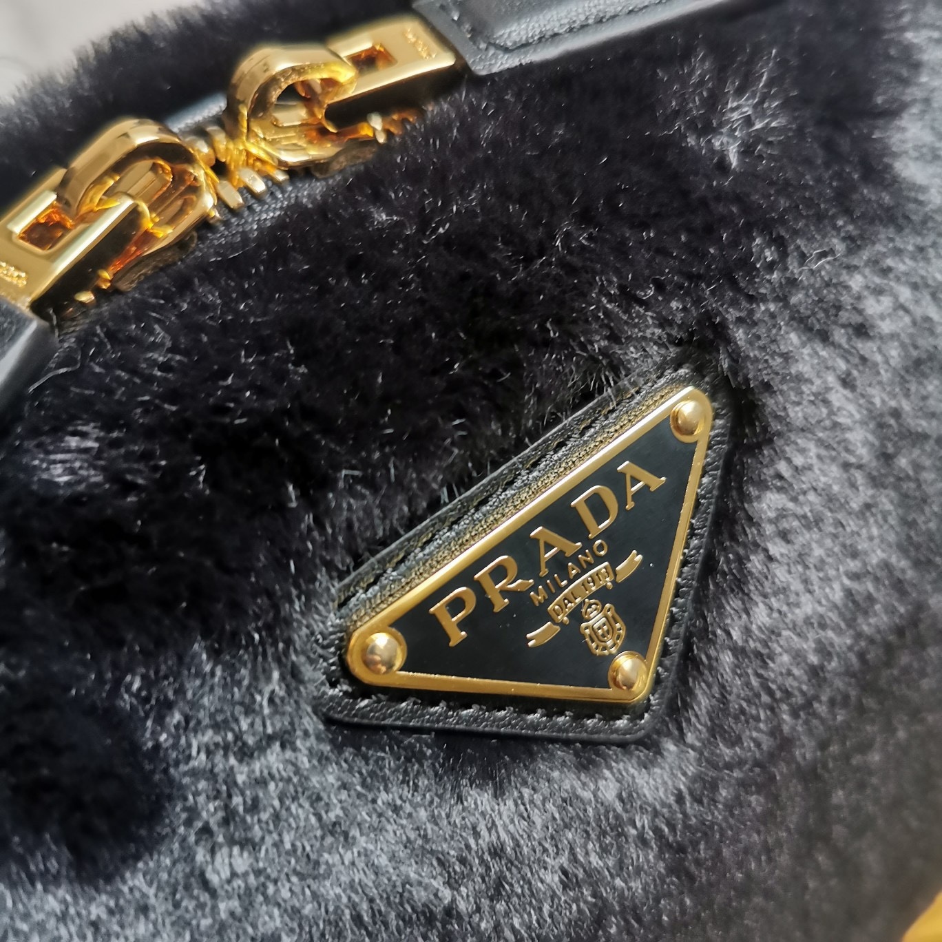 【 原單】🎉最新款迷你手袋🎉1BH208羊毛🎉🎉這款迷你手袋結構挺括，風格百搭，搭配柔軟的羊毛皮，彰顯冬日魅力。皮革細節與雙向拉鍊開合和金屬五金配件錦上添花，飾有塗琺瑯三角形金屬徽標。內配進口小羊皮，上身效果非常酷/時尚，冬天必備爆款🎉寶寶們，趕緊入手吧
尺寸：長19.5x高13x底6cm