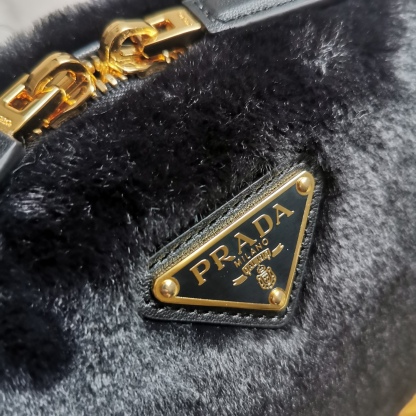 【 原單】🎉最新款迷你手袋🎉1BH208羊毛🎉🎉這款迷你手袋結構挺括，風格百搭，搭配柔軟的羊毛皮，彰顯冬日魅力。皮革細節與雙向拉鍊開合和金屬五金配件錦上添花，飾有塗琺瑯三角形金屬徽標。內配進口小羊皮，上身效果非常酷/時尚，冬天必備爆款🎉寶寶們，趕緊入手吧
尺寸：長19.5x高13x底6cm