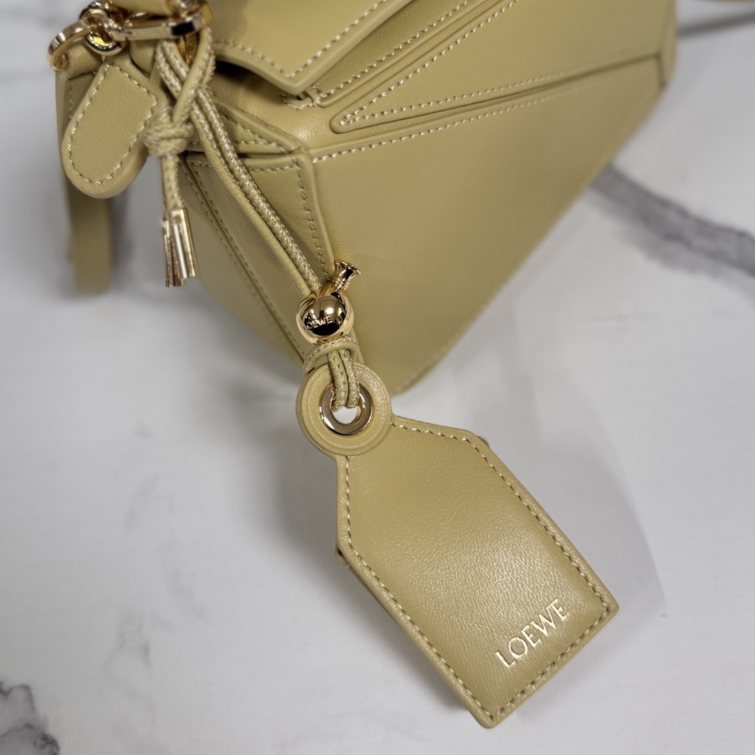 LO℮w℮🌟新款 迷你納帕羊皮革 Featherlight Puzzle 手袋 以別具一格的幾何線條勾勒長方體造型。柔軟輕盈的納帕皮革為手袋注入隨性慵懶的風格。可肩背、斜挎或手提
可拆卸可調節肩帶，飾有旋轉卡扣*拉鍊開合，鉸接式拉鍊頭 一個外部拉鍊後袋，一個內部插袋*可拆卸 LOE**WE 燙金或燙銀標籤，飾有隱秘口袋和氣球骰子*長方形金屬腳釘 納帕羊皮革襯里 Anagram 壓紋、飾牌內部鐫刻 LOE**WE.
型號：062511
size:17.5*7.5*12.5CM（配全套包裝）