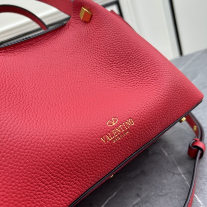 荔枝紋 Garavani VLOGO Escape 小牛皮小號購物袋，包袋兩側點綴紅色細節，金屬徽標飾件可用在包裝內部作為開合，亦可用在外部作為裝飾元素。
小號尺寸：31 *25*15 cm