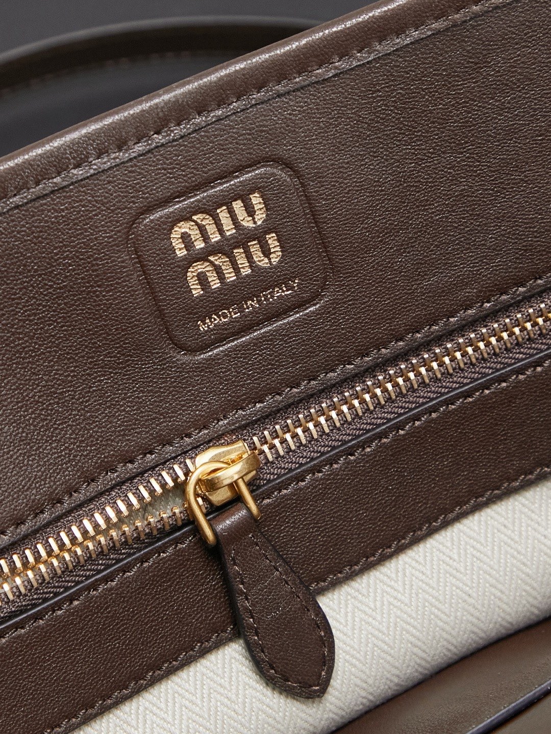 Aventure包袋展现出简约随性的魅力。重新诠释经典线条，这款柔软的Nappa变体展现出多功能和实用的态度，并通过精致独特的细节得到提升。aventure nappa皮革手袋灵感源自miu典藏设计，结构经过调整，变得更加轻便，焕发全新个性，饰以压花字母徽标，增添标志性元素，复古金色五金配件，亚麻混纺衬里，配拉链口袋和贴袋，长手腕适合用作手提或单肩