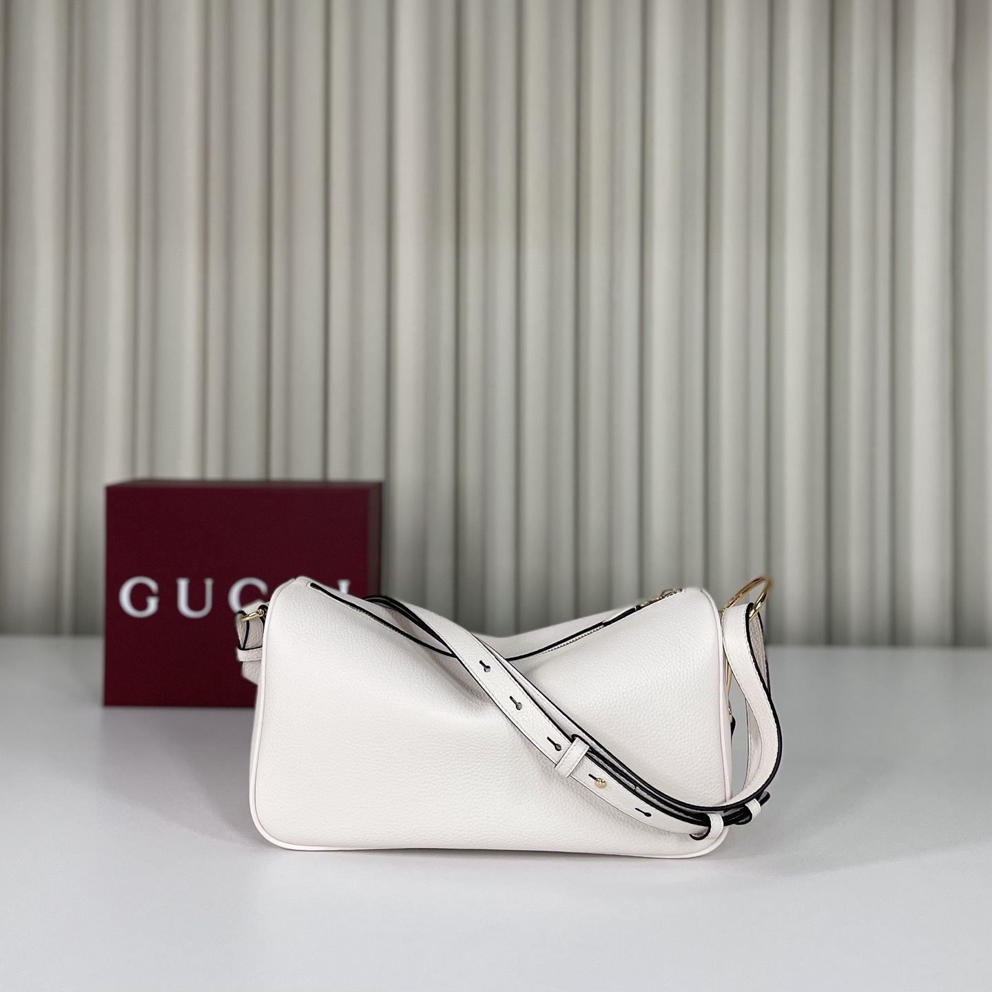 Gucci Half Horsebit系列中號肩背包，煥新呈現Gucci Half Horsebit系列，以現代風格煥新演繹品牌最具標誌性的元素之一。該系列巧妙融蘊休閒廓形與標誌性的半馬銜扣配件，這也是其名稱的由來。款號860787白皮，尺寸31.5X17X12