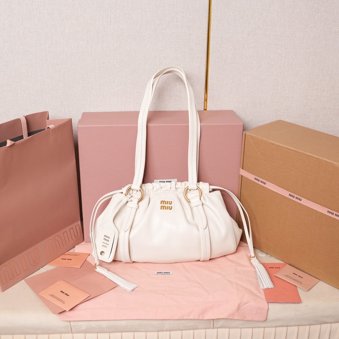 MIU中古腋下饺子包，全新植柔羊皮满满复古怀旧风情，搭配钢质做旧金属五金配件，质感高级典雅，袋口采用抽绳束口设计，细密的皱褶花边立体而俏皮，高级又不失慵懒随性，内搭全新条纹帆布里，配一个拉链隔层，独特的设计谁用谁好看