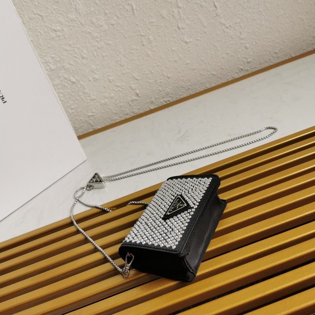 【 原單】🎉項鍊水晶小包🎉1MR024新色🎉🎉這款Duchesse面料卡片夾通體飾以仿水晶，於表面營造出光影格調和虹彩炫色，彰顯華美且不失功能性的設計。最愛是這條可拆卸可調節鐵璉肩帶，又可當腰包裝飾😍😍又可當搭配衣服項鍊裝飾，中間三角形標可調節活動，賦予單品多樣的佩戴方式。空間可裝口紅💄/耳機/鑰匙🚗....夜燈下bling bling,太美了。值得入手🎉🎉尺寸：長11.5cm*高8cm