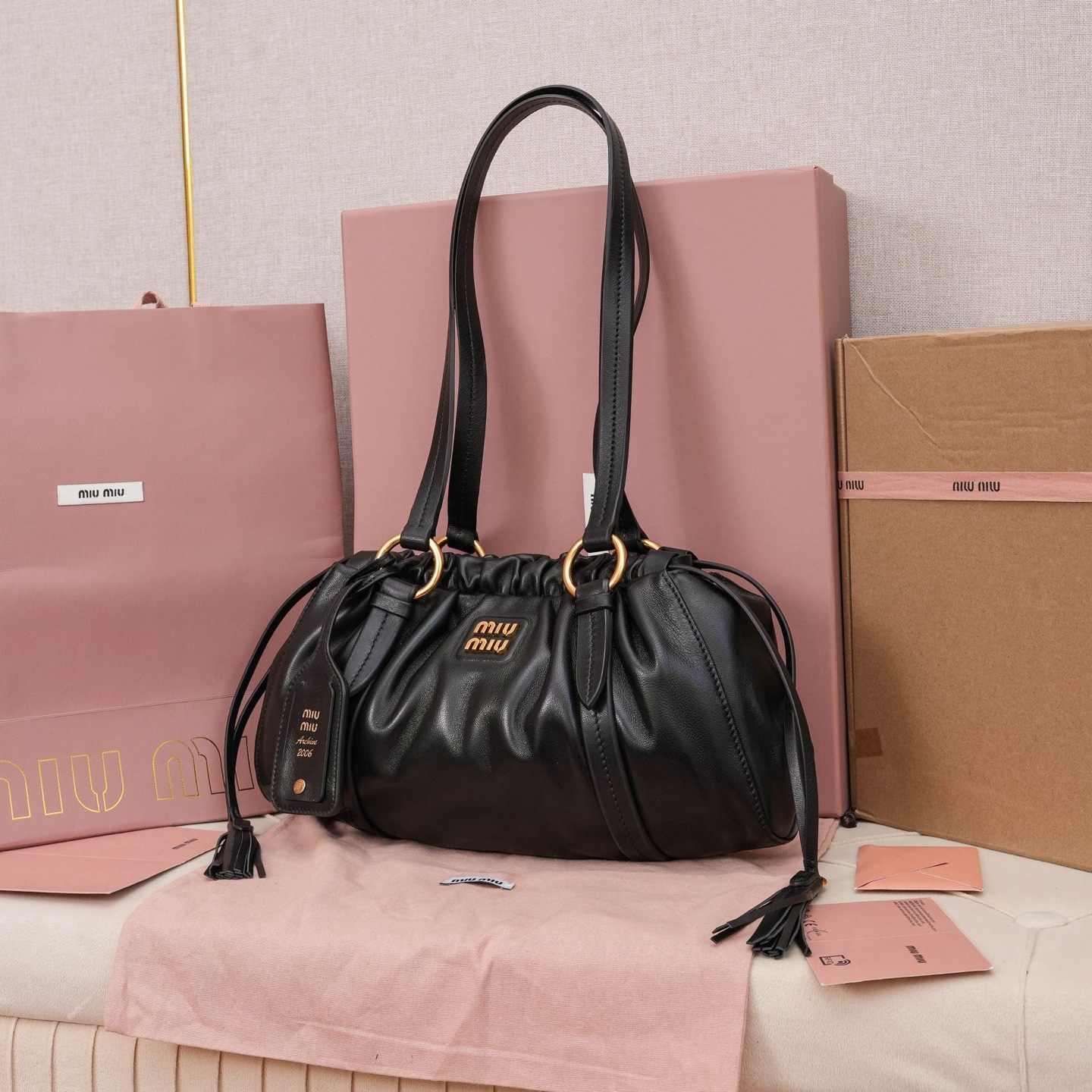 MIU中古腋下饺子包，全新植柔羊皮满满复古怀旧风情，搭配钢质做旧金属五金配件，质感高级典雅，袋口采用抽绳束口设计，细密的皱褶花边立体而俏皮，高级又不失慵懒随性，内搭全新条纹帆布里，配一个拉链隔层，独特的设计谁用谁好看