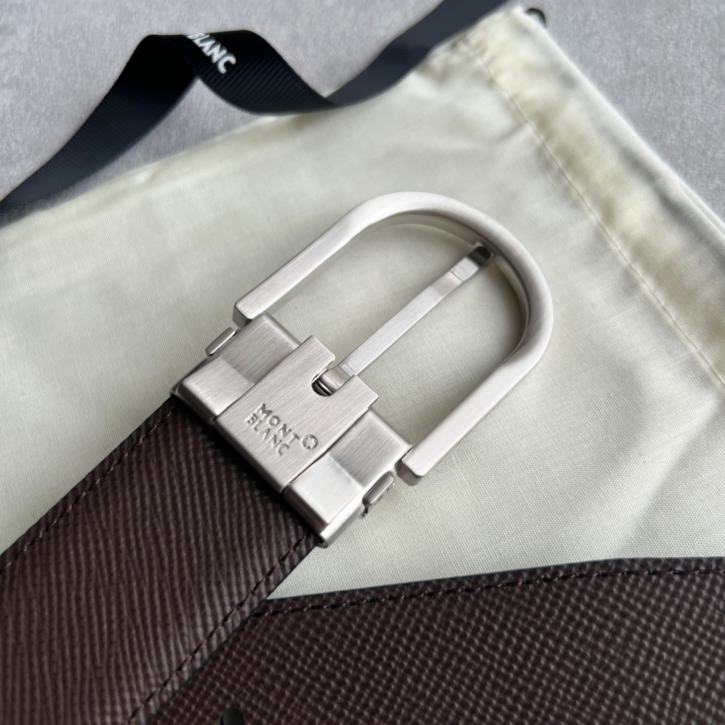 馬蹄形帶扣黑色/棕色雙面皮帶（35毫米）
馬蹄形閃亮鍍釕帶扣。可調節長度，3.5cm黑色和棕色雙面皮帶。打造經典靈動造型。
貨號 錶帶描述 黑色和棕色雙面牛皮皮帶 皮革圖案 金屬圓環上飾有萬寶龍六角白星 標識 搭扣裝置 易開啓裝置，可調節皮帶長度
搭扣形狀 馬蹄形主要顏色 黑色 | 棕色 搭扣類型 針扣式表扣