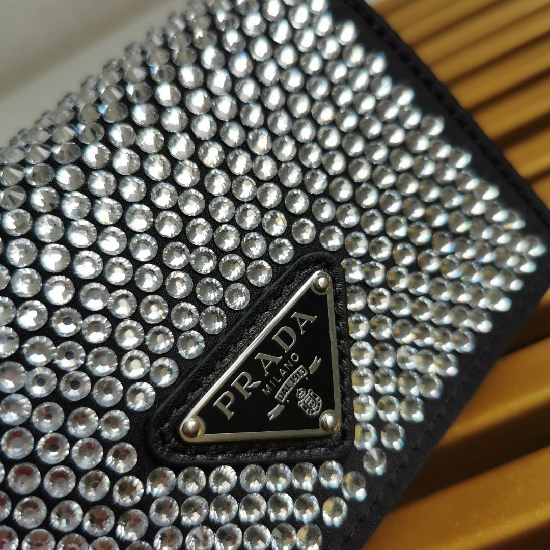 【 原單】🎉項鍊水晶小包🎉1MR024新色🎉🎉這款Duchesse面料卡片夾通體飾以仿水晶，於表面營造出光影格調和虹彩炫色，彰顯華美且不失功能性的設計。最愛是這條可拆卸可調節鐵璉肩帶，又可當腰包裝飾😍😍又可當搭配衣服項鍊裝飾，中間三角形標可調節活動，賦予單品多樣的佩戴方式。空間可裝口紅💄/耳機/鑰匙🚗....夜燈下bling bling,太美了。值得入手🎉🎉尺寸：長11.5cm*高8cm