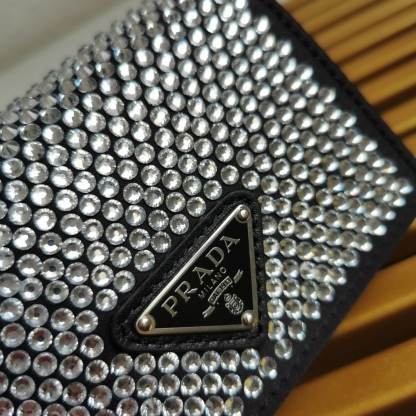 【 原單】🎉項鍊水晶小包🎉1MR024新色🎉🎉這款Duchesse面料卡片夾通體飾以仿水晶，於表面營造出光影格調和虹彩炫色，彰顯華美且不失功能性的設計。最愛是這條可拆卸可調節鐵璉肩帶，又可當腰包裝飾😍😍又可當搭配衣服項鍊裝飾，中間三角形標可調節活動，賦予單品多樣的佩戴方式。空間可裝口紅💄/耳機/鑰匙🚗....夜燈下bling bling,太美了。值得入手🎉🎉尺寸：長11.5cm*高8cm