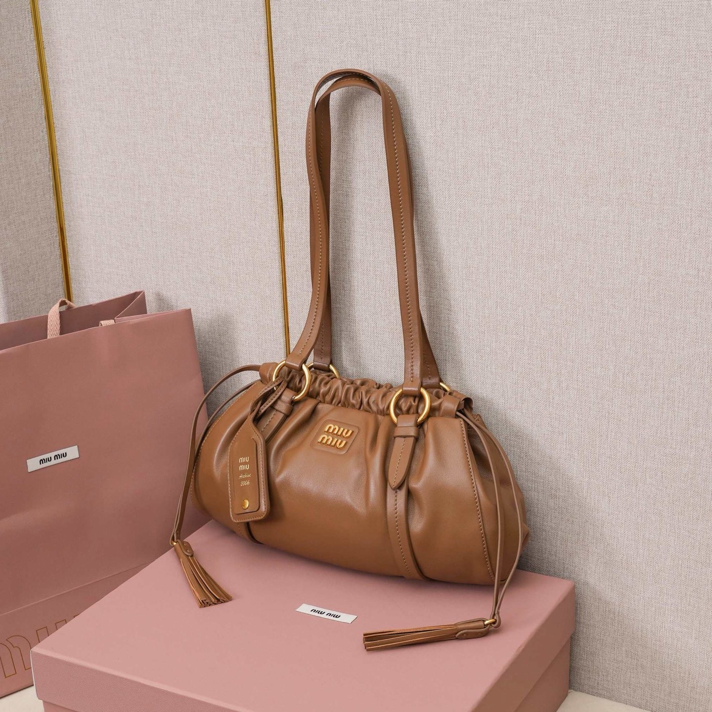 MIU中古腋下饺子包，全新植柔羊皮满满复古怀旧风情，搭配钢质做旧金属五金配件，质感高级典雅，袋口采用抽绳束口设计，细密的皱褶花边立体而俏皮，高级又不失慵懒随性，内搭全新条纹帆布里，配一个拉链隔层，独特的设计谁用谁好看