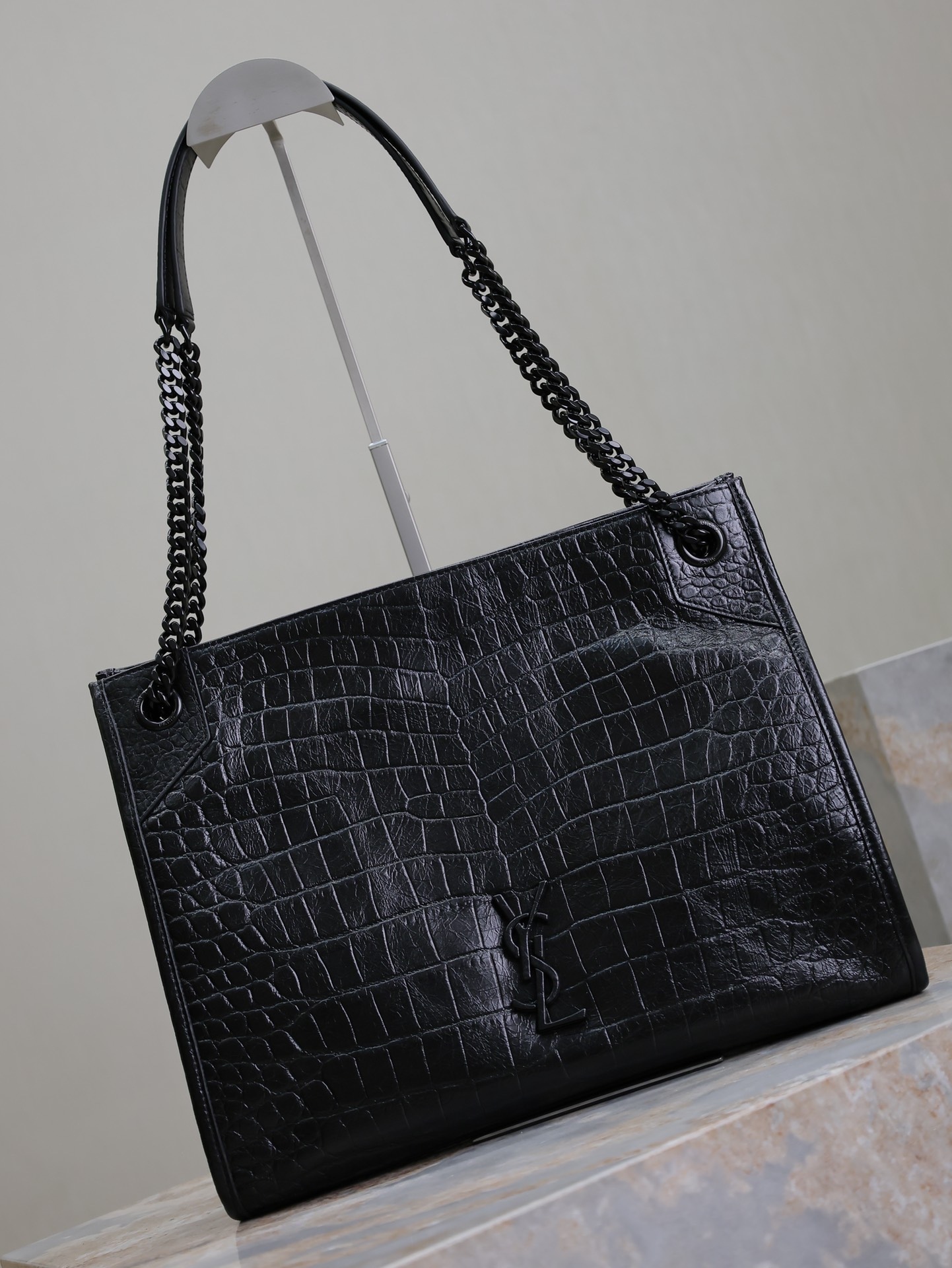 黑色黑扣鰐魚紋·
Niki shopping bag_
意大利進口鰐魚壓紋牛皮，五金是全牛皮包裹，工藝十分精湛！包袋中間有磁吸扣，保障了包包使用的安全性；內里有一拉鍊隔層及敞口插槽設計可放手機及零錢卡片，方便拿取，不會出現因為是大包而出現找不到東西的情況；包包自重非常輕，容量又足夠大，公文包、旅行包、購物袋、媽媽包隨意切換，實用性爆表！
型號：577999
尺寸：33x27x11.5cm