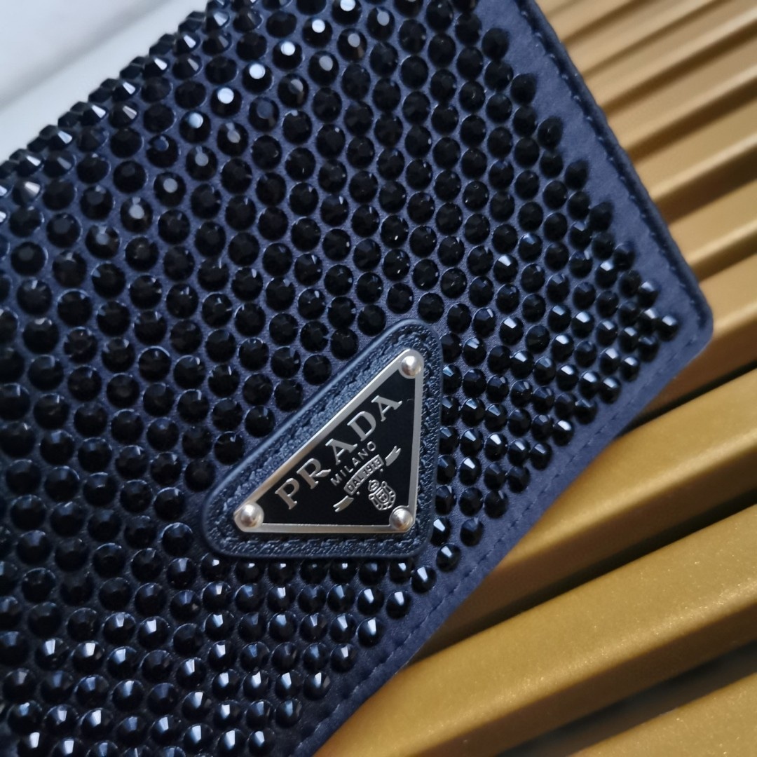 【 原單】🎉項鍊水晶小包🎉1MR024新色🎉🎉這款Duchesse面料卡片夾通體飾以仿水晶，於表面營造出光影格調和虹彩炫色，彰顯華美且不失功能性的設計。最愛是這條可拆卸可調節鐵璉肩帶，又可當腰包裝飾😍😍又可當搭配衣服項鍊裝飾，中間三角形標可調節活動，賦予單品多樣的佩戴方式。空間可裝口紅💄/耳機/鑰匙🚗....夜燈下bling bling,太美了。值得入手🎉🎉尺寸：長11.5cm*高8cm