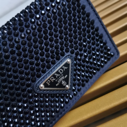 【 原單】🎉項鍊水晶小包🎉1MR024新色🎉🎉這款Duchesse面料卡片夾通體飾以仿水晶，於表面營造出光影格調和虹彩炫色，彰顯華美且不失功能性的設計。最愛是這條可拆卸可調節鐵璉肩帶，又可當腰包裝飾😍😍又可當搭配衣服項鍊裝飾，中間三角形標可調節活動，賦予單品多樣的佩戴方式。空間可裝口紅💄/耳機/鑰匙🚗....夜燈下bling bling,太美了。值得入手🎉🎉尺寸：長11.5cm*高8cm