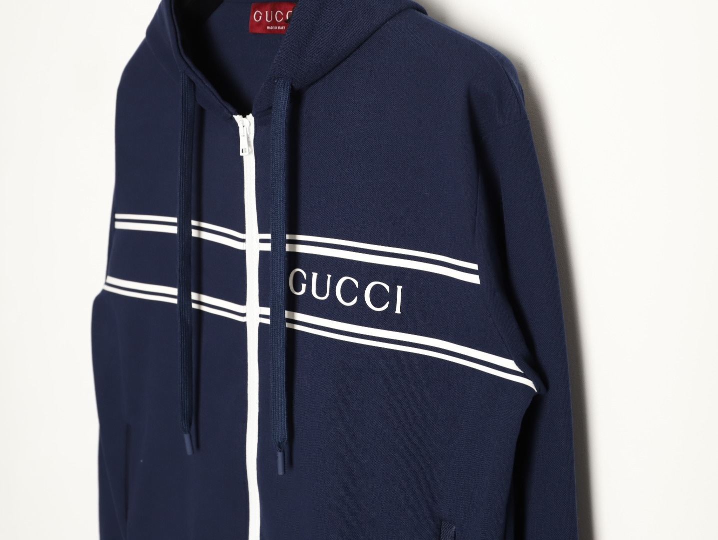 Gucci/古馳 G字母膠條拉鍊連帽外套
這款單品出自Lido系列，設計靈感源自意大利海岸的夏日風情和海灘俱樂部，早秋系列聚焦基礎廓形與經典細節，匠心呈獻日常服飾和晚裝造型，這款休閒連帽衛衣採用平紋針織面料精制而成，中央貫穿點綴G標識條紋印花，男女同款，定制輔料三標
A Size:S-XL