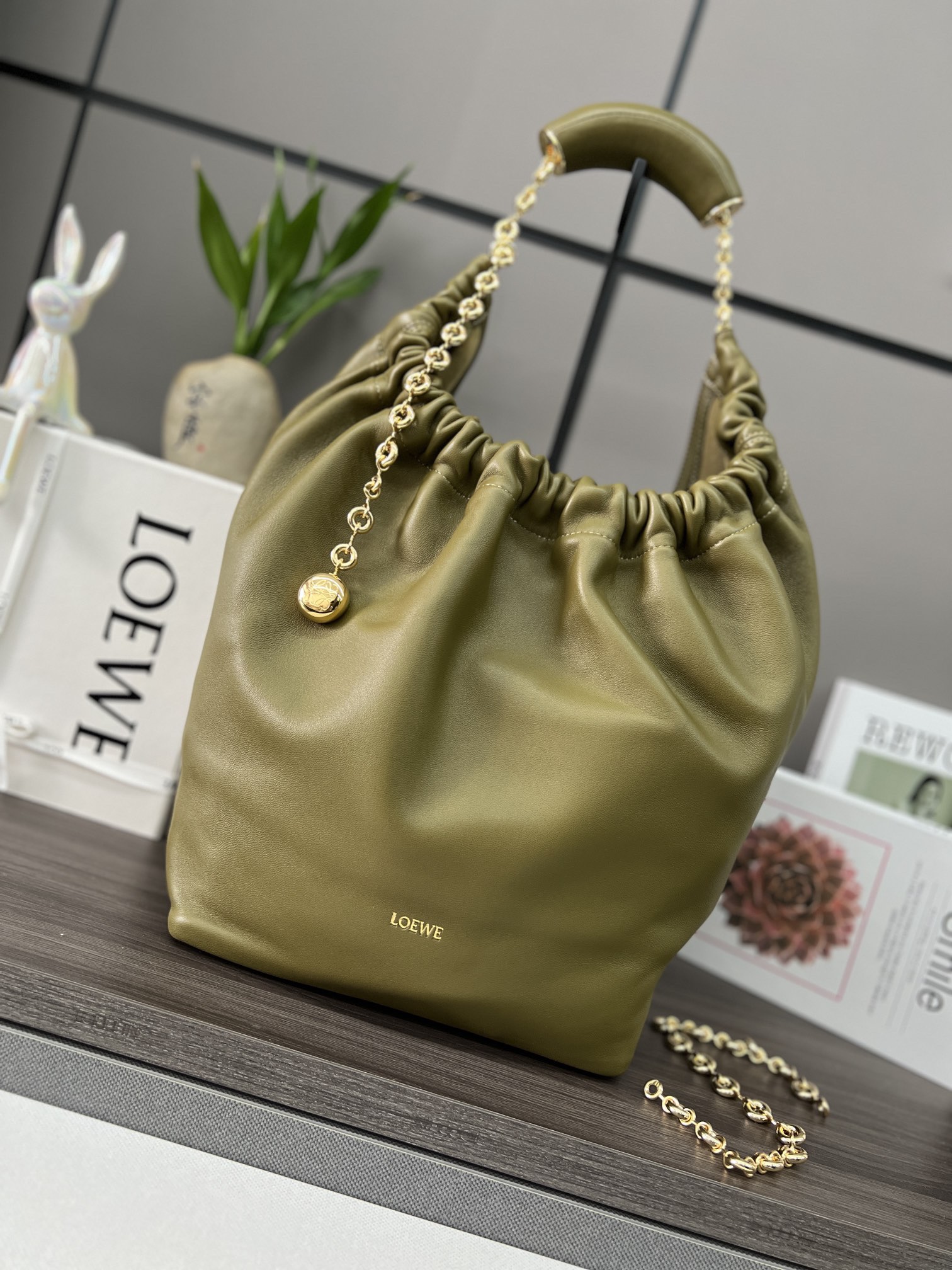 LO℮w℮🌟中號🆕納帕羊皮Squeeze手袋👜一款精緻而柔美的全新手袋，採用觸感柔軟的納帕皮革製成。這款順手藝是傳統工藝、創新研究和獨特設計的傑作，具備令人驚訝的輕盈褶皺包身、可調節甜甜圈鏈條和觸感柔軟的提手。此中號版本採用納帕羊皮革打造。*可肩背、斜挎或手提*可調節鏈條肩帶，搭配Anagram攜刻鵝卵石，附加額外鏈條，可進一步延長肩帶*磁扣開合*內部拉鍊口袋*無襯里*lo*ewe燙金或燙銀。
size：34*13.5*33CM
型號：652328 全鋼五金