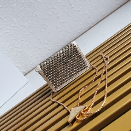 【 原單】🎉2023新款金色系項鍊水晶小包🎉1MR024🎉🎉這款Duchesse面料卡片夾通體飾以仿水晶，於表面營造出光影格調和虹彩炫色，彰顯華美且不失功能性的設計。最愛是這條可拆卸可調節鐵璉肩帶，又可當腰包裝飾😍😍又可當搭配衣服項鍊裝飾，中間三角形標可調節活動，賦予單品多樣的佩戴方式。空間可裝口紅💄/耳機/鑰匙🚗....夜燈下bling bling,太美了。值得入手🎉🎉尺寸：長11.5cm*高8cm