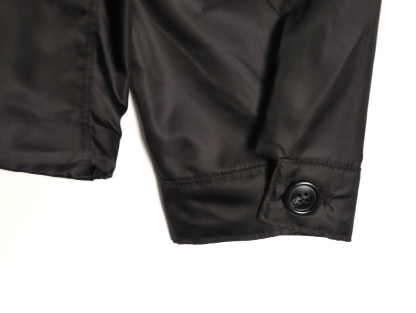 🔝PRADA/普拉達PRD 拉鍊口袋尼龍連帽外套
選用品牌標誌性的再生尼龍面料，與傳統尼龍性能相當，具備高強度，抗撕裂，耐磨損等特性。其質地輕盈，同時又具備防水功能適合多場景需求。抗皺，快乾的特點也易於日常打理維護。
定制三角徽標通過4個0.8mm金屬爪釘固定於衣身，爪釘背面經手工打磨至圓潤，避免刮蹭。下擺彈力抽繩選用7芯高彈尼龍繩，直徑3mm，配合橡膠扣，可實現±5cm長度調節。抽繩孔採用「金屬雞眼+防磨環」雙重保護，雞眼內徑5mm，邊緣光滑無毛刺，反復抽拉500次無變形。
袖口採用紐扣調