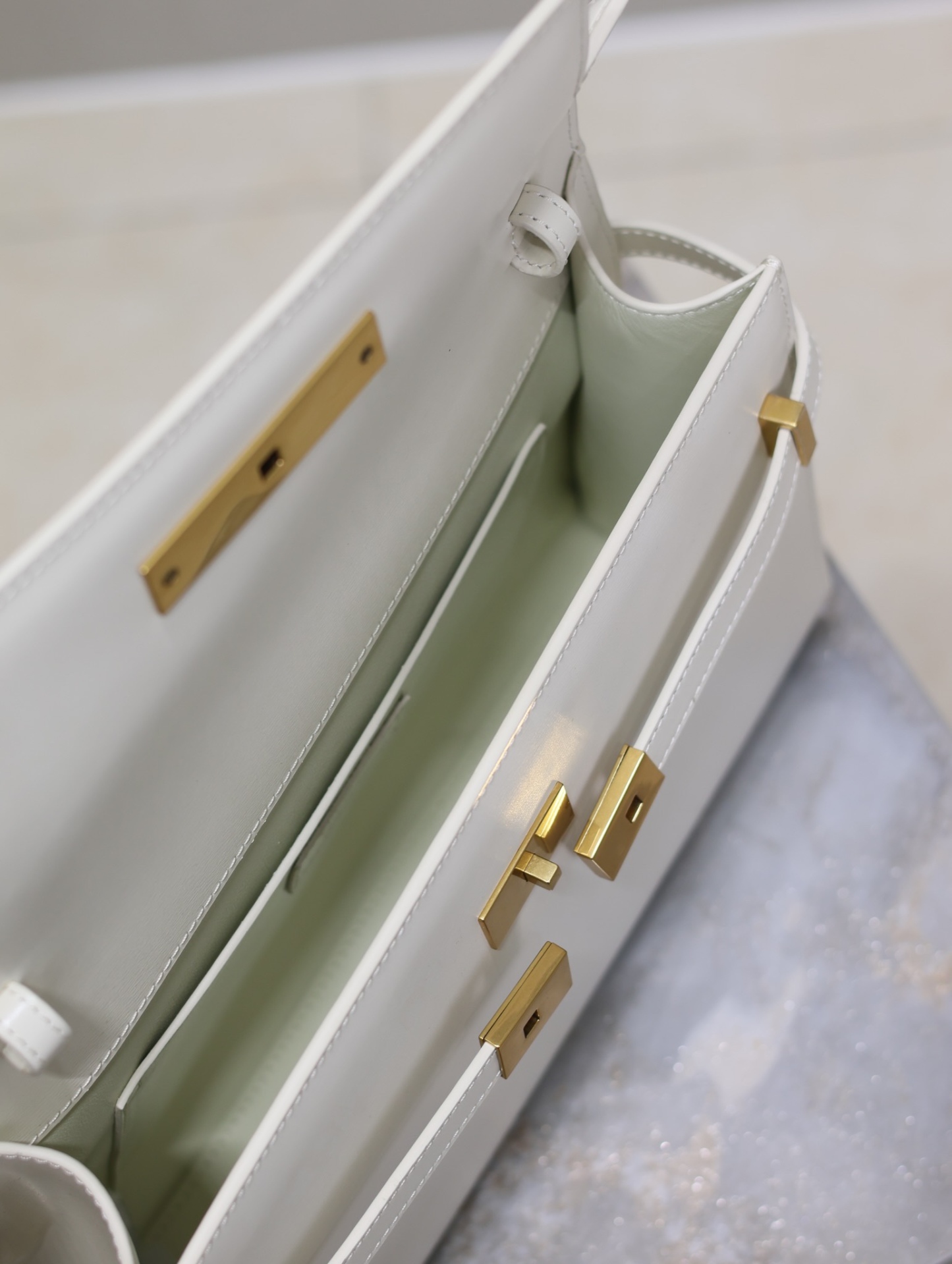 Manhattan_29cm
翻蓋曼哈頓法棍包，一改以往經典的logo，取而代之低調簡約的設計風格，它有點像H家的凱莉，很有復古的味道！商務➕休閒兩者結合，總結起來就是百搭！可以手拿，可以單肩或斜挎，一包多用，滿足了商務型女士，又滿足了小女生的休閒！精心挑選的意大利牙簽紋牛皮、完美的走線、精緻的五金讓整個包包都散髮出高級的味道！
型號：579271
尺寸：29x20.5x7cm