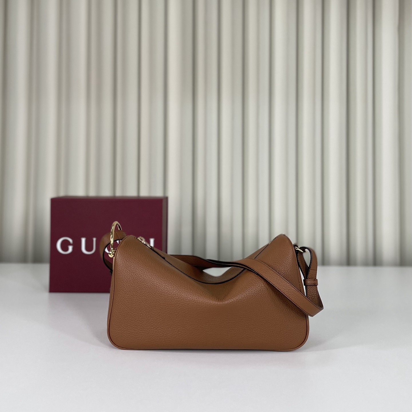 Gucci Half Horsebit系列中號肩背包，煥新呈現Gucci Half Horsebit系列，以現代風格煥新演繹品牌最具標誌性的元素之一。該系列巧妙融蘊休閒廓形與標誌性的半馬銜扣配件，這也是其名稱的由來。款號860787白皮，尺寸31.5X17X12