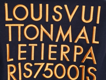 Louis Vuitton/路易威登 26ss 水鑽刺繡棒球服外套
材質拼接：衣身採用藏青色羊毛混紡面料，質感挺括耐磨；袖子為淺棕牛皮材質，柔軟細膩，經典拼皮設計還原美式棒球服復古感。

• 裝飾亮點：左胸位置有重工水鑽+金屬刺繡裝飾，鑲嵌多色寶石與閃鑽，綴有“L.V.M.”字母標識，華麗精緻，辨識度拉滿。

• 版型結構：立領+羅紋條紋領口/袖口/下擺，防風且修飾身形；正面按扣開合，兩側配有插袋，兼顧實用與美觀。
球帽點綴，休閒隨性又有街頭感。
N Size:S-XL