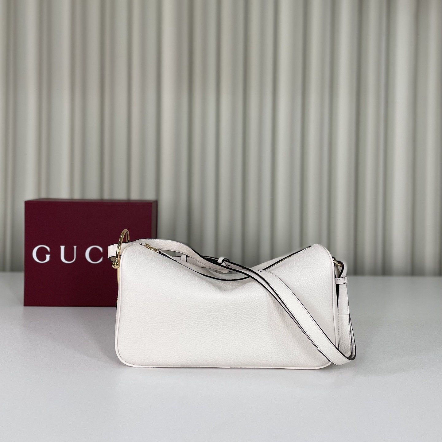 Gucci Half Horsebit系列中號肩背包，煥新呈現Gucci Half Horsebit系列，以現代風格煥新演繹品牌最具標誌性的元素之一。該系列巧妙融蘊休閒廓形與標誌性的半馬銜扣配件，這也是其名稱的由來。款號860787白皮，尺寸31.5X17X12