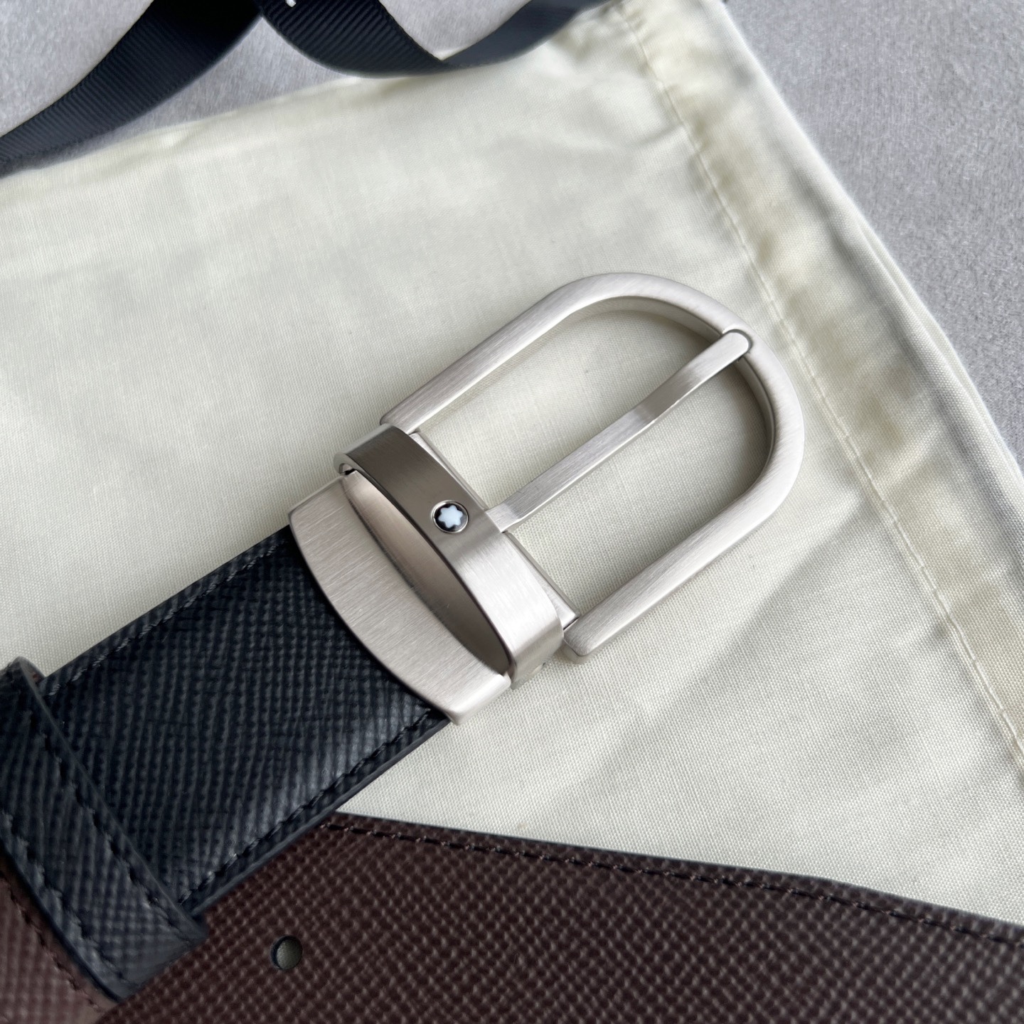 馬蹄形帶扣黑色/棕色雙面皮帶（35毫米）
馬蹄形閃亮鍍釕帶扣。可調節長度，3.5cm黑色和棕色雙面皮帶。打造經典靈動造型。
貨號 錶帶描述 黑色和棕色雙面牛皮皮帶 皮革圖案 金屬圓環上飾有萬寶龍六角白星 標識 搭扣裝置 易開啓裝置，可調節皮帶長度
搭扣形狀 馬蹄形主要顏色 黑色 | 棕色 搭扣類型 針扣式表扣