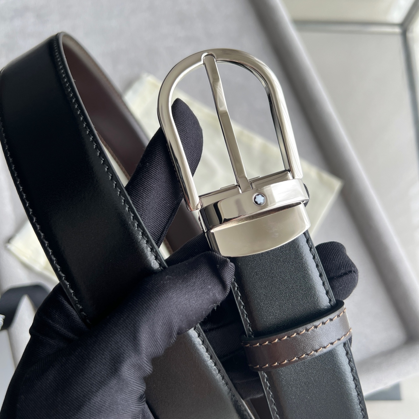 馬蹄形帶扣黑色/棕色雙面皮帶（35毫米）
馬蹄形閃亮鍍釕帶扣。可調節長度，3.5cm黑色和棕色雙面皮帶。打造經典靈動造型。
貨號 錶帶描述 黑色和棕色雙面牛皮皮帶 皮革圖案 金屬圓環上飾有萬寶龍六角白星 標識 搭扣裝置 易開啓裝置，可調節皮帶長度
搭扣形狀 馬蹄形主要顏色 黑色 | 棕色 搭扣類型 針扣式表扣