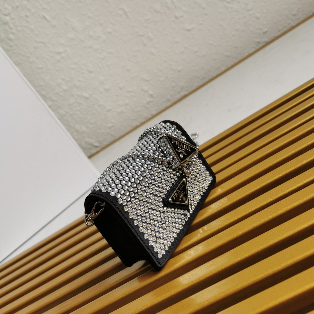 【 原單】🎉項鍊水晶小包🎉1MR024新色🎉🎉這款Duchesse面料卡片夾通體飾以仿水晶，於表面營造出光影格調和虹彩炫色，彰顯華美且不失功能性的設計。最愛是這條可拆卸可調節鐵璉肩帶，又可當腰包裝飾😍😍又可當搭配衣服項鍊裝飾，中間三角形標可調節活動，賦予單品多樣的佩戴方式。空間可裝口紅💄/耳機/鑰匙🚗....夜燈下bling bling,太美了。值得入手🎉🎉尺寸：長11.5cm*高8cm