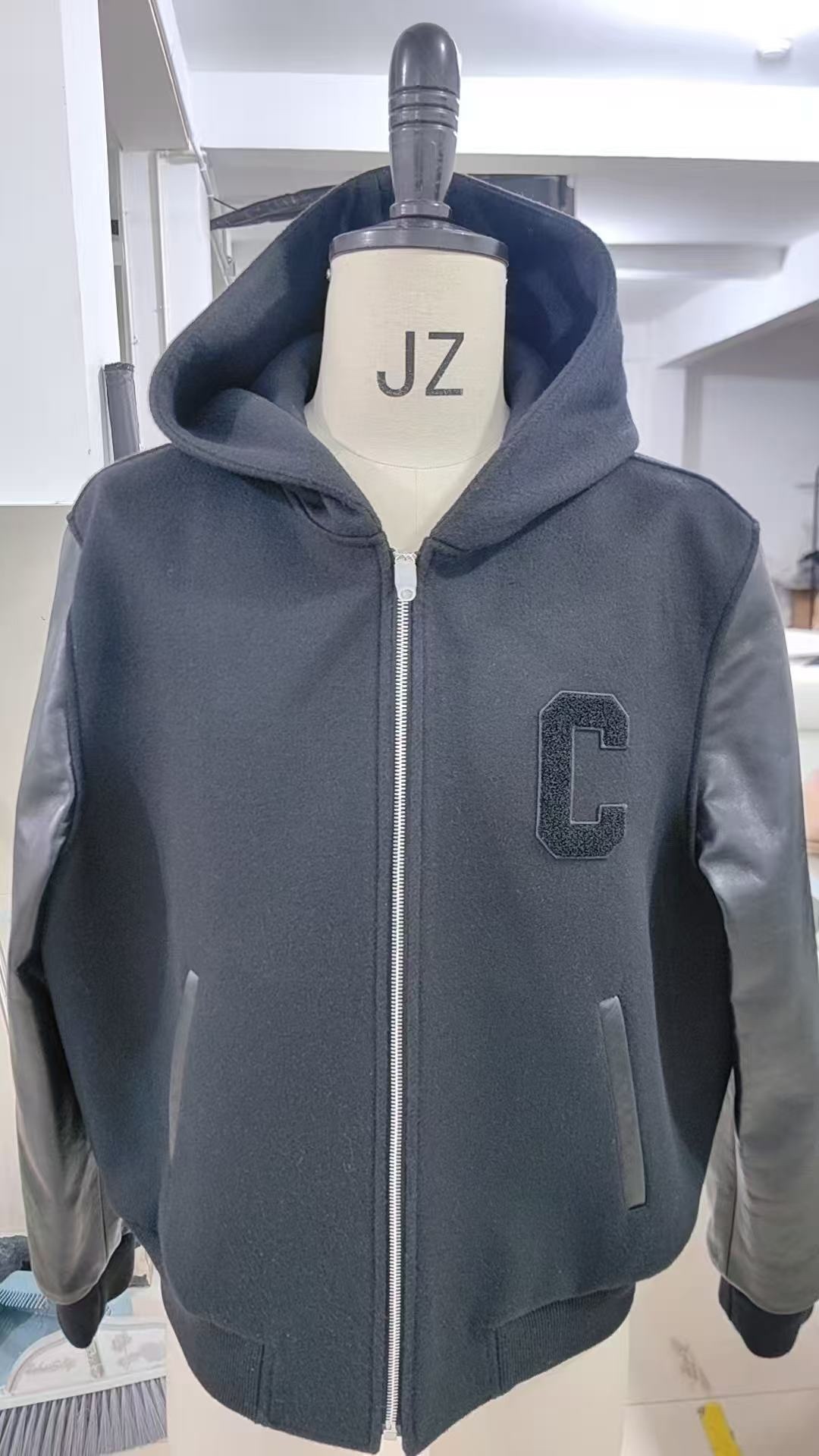 🔝CELINE賽琳CE 大C毛呢皮袖連帽外套
主體採用羊毛混紡面料，經特殊編織工藝打造，質地厚實而不失柔軟，呈現細膩的啞光光澤。羊毛纖維經過預縮處理，有效避免穿著後的變形與起球，同時保留天然的保暖性與透氣性。衣袖部分選用皮革，通過特殊處理賦予皮革細膩的粒面紋理與溫潤光澤，隨著穿著會逐漸形成獨特的使用痕跡，成為專屬的時光印記。內襯採用100%粘膠纖維，手感絲滑且垂墜感佳，與面料形成良好的內外呼應，提升穿著舒適度。
胸前C字貼飾採用毛巾繡工藝，以6mm粗細的紗線層層堆疊，形成飽滿的立體肌理。刺繡