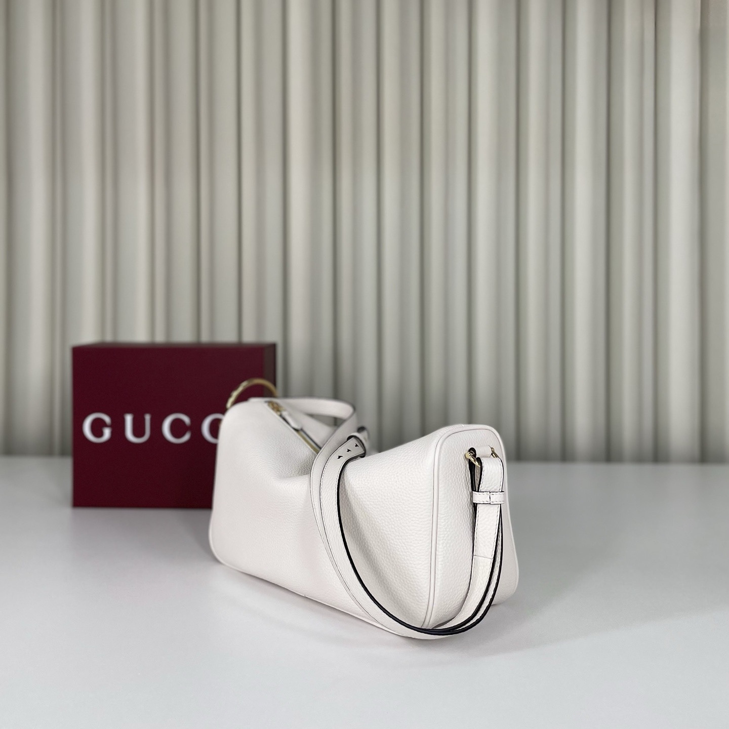 Gucci Half Horsebit系列中號肩背包，煥新呈現Gucci Half Horsebit系列，以現代風格煥新演繹品牌最具標誌性的元素之一。該系列巧妙融蘊休閒廓形與標誌性的半馬銜扣配件，這也是其名稱的由來。款號860787白皮，尺寸31.5X17X12