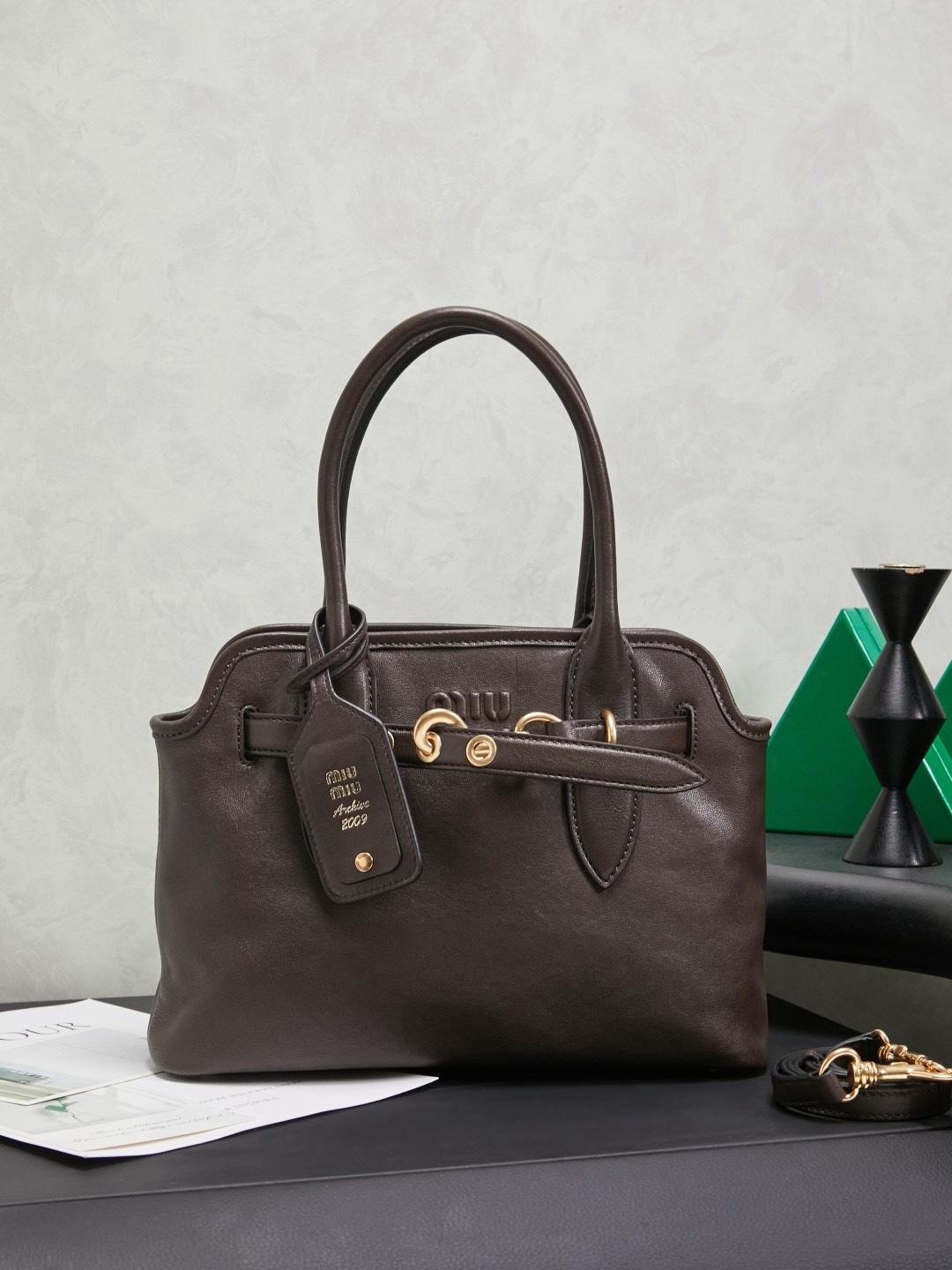 Aventure包袋展现出简约随性的魅力。重新诠释经典线条，这款柔软的Nappa变体展现出多功能和实用的态度，并通过精致独特的细节得到提升。aventure nappa皮革手袋灵感源自miu典藏设计，结构经过调整，变得更加轻便，焕发全新个性，饰以压花字母徽标，增添标志性元素，复古金色五金配件，亚麻混纺衬里，配拉链口袋和贴袋，长手腕适合用作手提或单肩