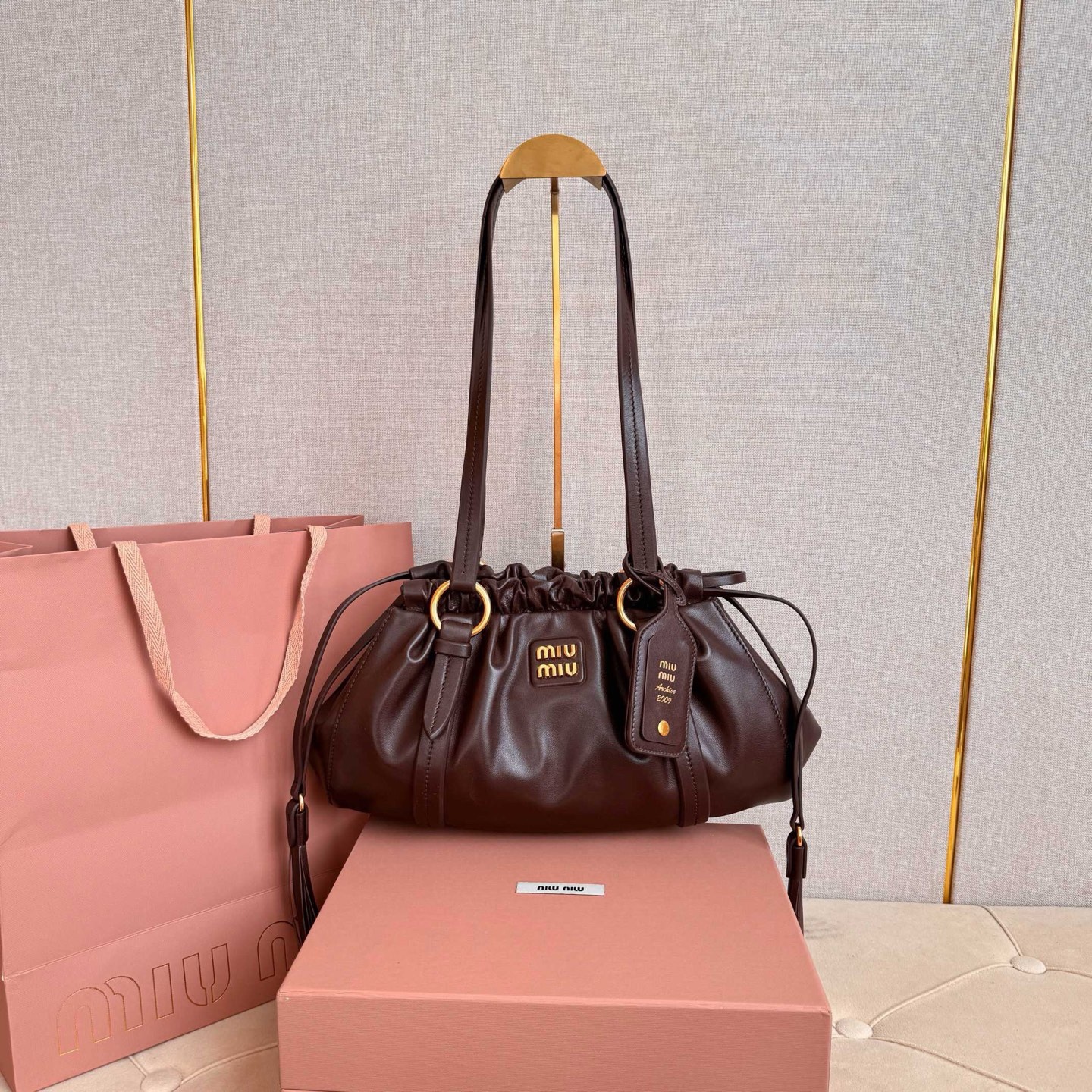 MIU中古腋下饺子包，全新植柔羊皮满满复古怀旧风情，搭配钢质做旧金属五金配件，质感高级典雅，袋口采用抽绳束口设计，细密的皱褶花边立体而俏皮，高级又不失慵懒随性，内搭全新条纹帆布里，配一个拉链隔层，独特的设计谁用谁好看