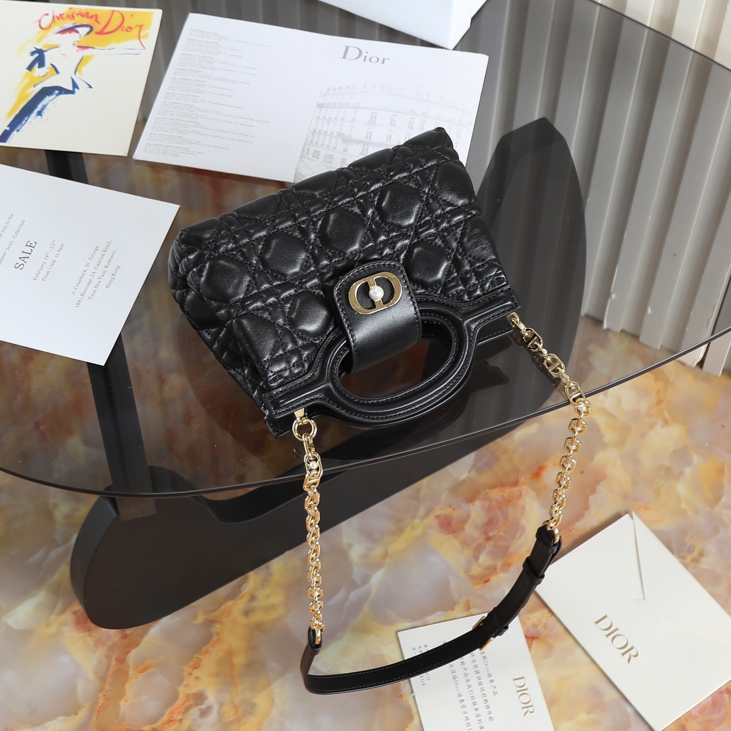 原廠級 黑色鏈條手袋
這款 Dior Jolie Top Handle 迷你鏈條手袋是二零二六早春成衣系列新品，呈現出優雅精緻的設計。採用黑色羊皮革精心製作，飾以藤格紋，翻蓋點綴以金色飾面金屬 CD 標誌和白色樹脂珠飾。內設一個隔層，可收納各種日常用品。搭配雙頂部手柄和可調節、可拆卸 CD 鏈條肩帶，肩帶由皮革帶和 CD 鏈環組成，飾以白色樹脂珠飾，可舒適手提、肩背或斜挎，可與日常或晚裝造型搭配。
