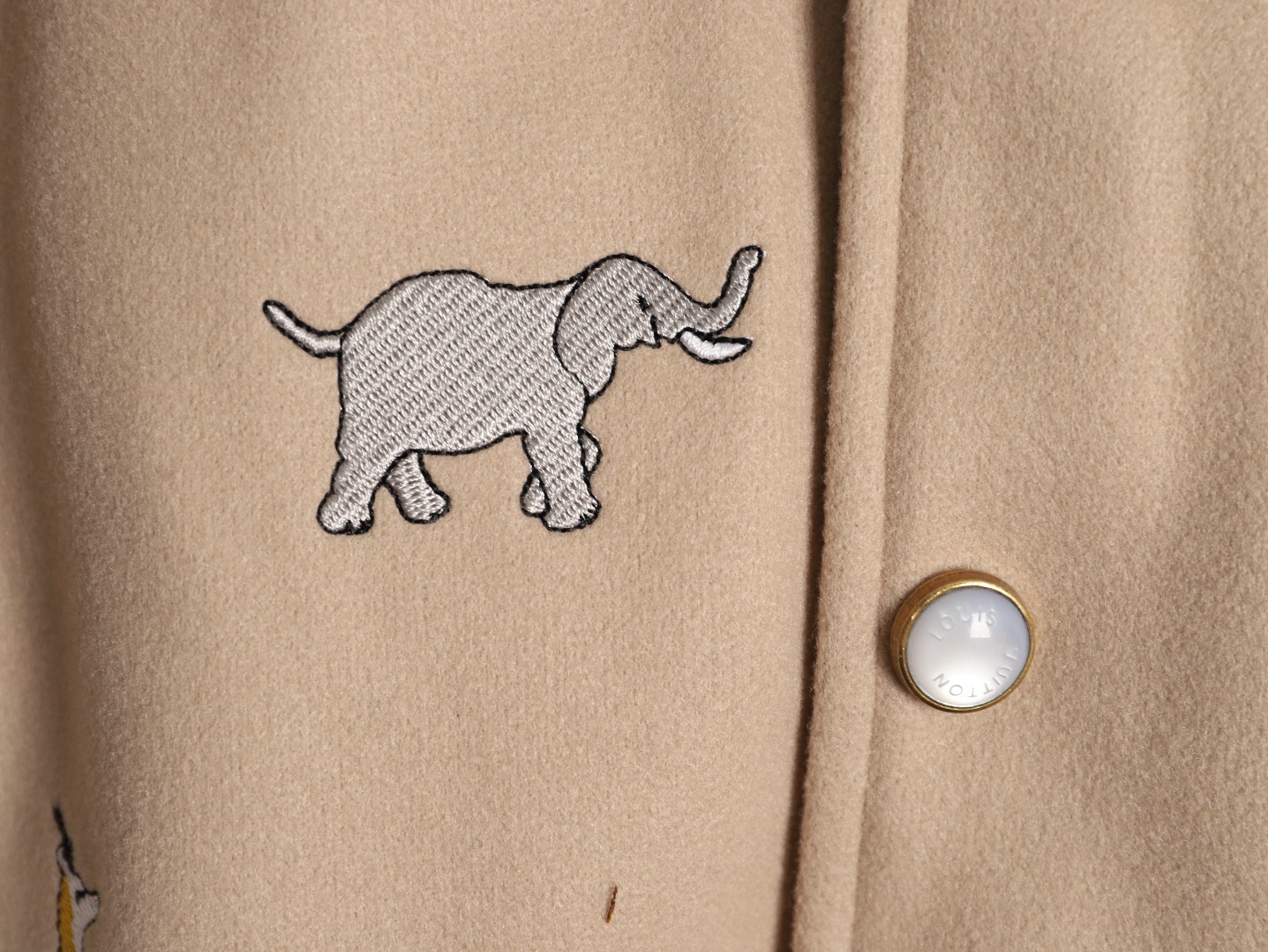 Louis Vuitton/路易威登 26ss 動物樂園刺繡棒球服外套
材質拼接：衣身採用淺卡其色羊毛混紡面料，柔軟且有挺括感；袖子為奶白色荔枝紋牛皮，質感細膩，淺色系搭配更顯清爽。

• 裝飾亮點：衣身滿印精緻動物刺繡（長頸鹿、斑馬、大象、黑豹等）與棕櫚樹圖案，左胸綴有“L.V.M.”字母標識，充滿童趣與度假感，辨識度極高。

• 版型結構：經典棒球服版型，羅紋條紋領口/袖口/下擺，防風收型；正面按扣開合，兩側配白色撞色插袋，兼顧實用性與設計感。
N SIZE:S-XL
