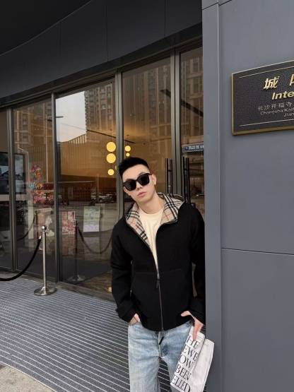 🔝BURBERRY巴寶莉BBR 雙面穿羊毛連帽外套
精選雙面羊毛斜紋面料，通過獨特的拉絨工藝處理，使表層呈現細膩豐盈的絨毛質感，觸感如雲朵般柔軟親膚，同時保留羊毛天然的保暖性與透氣性。一面以沈穩黑色演繹低調奢華，另一面則鋪滿標誌性的紅、黑、駝三色交織的經典圖案，既是品牌視覺符號，也為穿搭注入復古氣息。雙面可穿的設計，讓一件外套擁有兩種風格。
選用優質羊絨纖維進行精細紡紗，確保紗線的均勻性和強度。然後，通過先進的織造技術將紗線織成具有雙面效果的毛呢面料。
面料在裁剪前會經過預縮處理