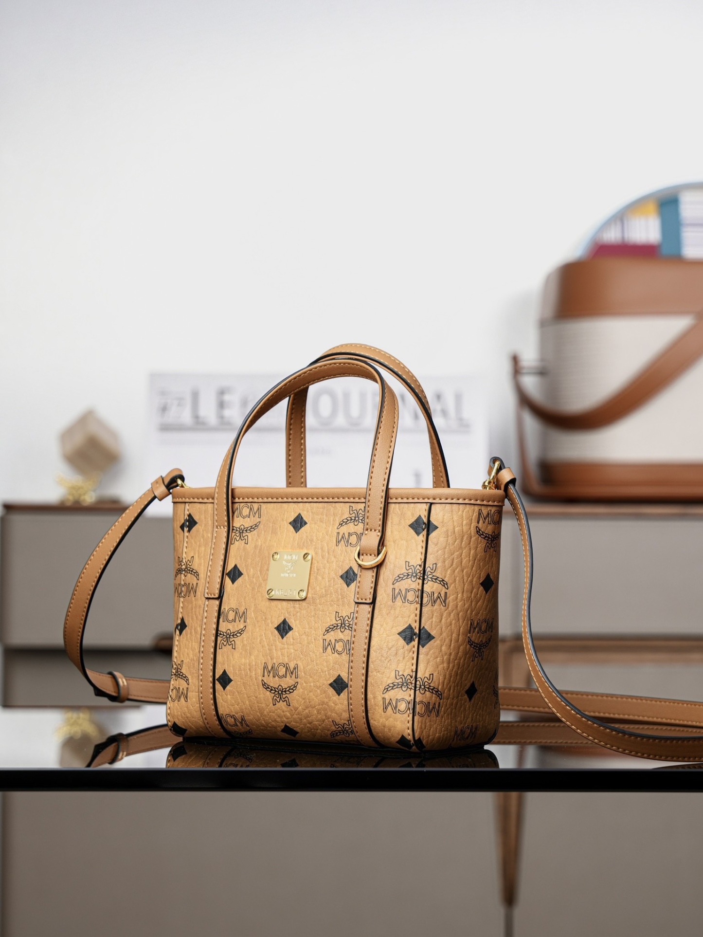 ®全新升級®官網同步
𝙈𝘾𝙈 𝙏𝙤𝙣𝙞 𝙓-𝙈𝙞𝙣𝙞
超迷你乾邑色#菜籃子

·CP獨家出品｜乾邑色
🉑️單肩🉑️斜挎 官網同步上新！
這款縮小版的Toni購物袋採用獨特的幾何設計，是一款小巧的隨身包袋。柔軟的皮革提手及可調節的皮革肩帶則可實現兩種攜帶方式。

型號：MWPFSMT03CO001
尺寸：16*9*14cm
肩帶：可調節100-126cm
開合：拉鍊式
顏色：乾邑色/Cognac🟫