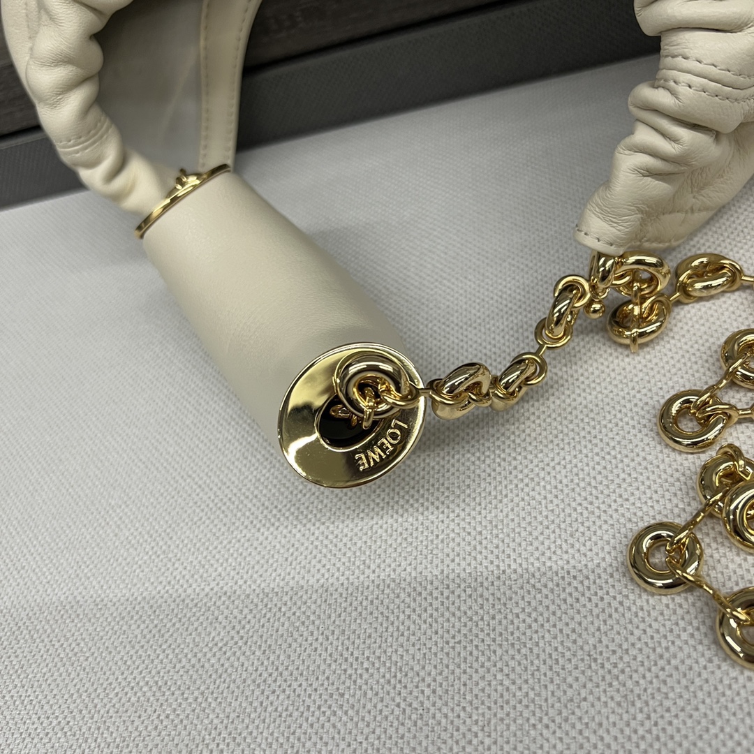 LO℮w℮🌟小號🆕納帕羊皮Squeeze手袋👜一款精緻而柔美的全新手袋，採用觸感柔軟的納帕皮革製成。這款順手藝是傳統工藝、創新研究和獨特設計的傑作，具備令人驚訝的輕盈褶皺包身、可調節甜甜圈鏈條和觸感柔軟的提手。此小號版本採用納帕羊皮革打造。*可肩背、斜挎或手提*可調節鏈條肩帶，搭配Anagram攜刻鵝卵石，附加額外鏈條，可進一步延長肩帶*磁扣開合*內部拉鍊口袋*無襯里*lo*ewe燙金或燙銀。
size：29*10.5*24CM
型號：652329 全鋼五金（配全套包裝）