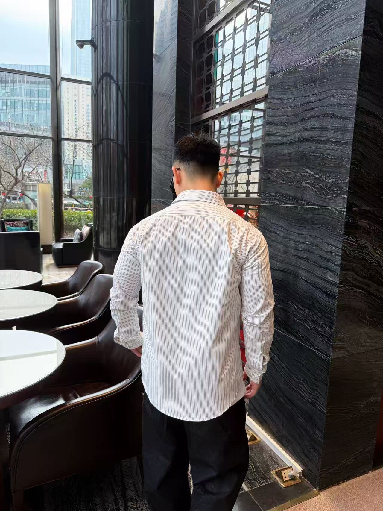 🔝CELINE賽琳CE 凱旋門竪條紋刺繡長袖襯衫
採用100%天然棉花纖維，無任何化纖混紡，從源頭確保面料的純淨度。棉纖維內部的中空結構形成天然“空氣通道”，使面料具備優異的透氣性。空氣可自由流通於纖維間隙，快速排出體表濕氣與熱量，即使長時間穿著也能保持乾爽，避免悶熱黏膩感。同時吸濕性遠超合成纖維。當人體出汗時，面料能迅速吸收汗液並擴散至表面，通過空氣流動加速蒸發，實現“吸濕-釋放”的動態平衡，保持肌膚乾爽舒適。
繡花機以棉線勾勒標誌，針腳細密均勻，確保線條流暢清晰，形成飽滿的立體肌理。刺繡