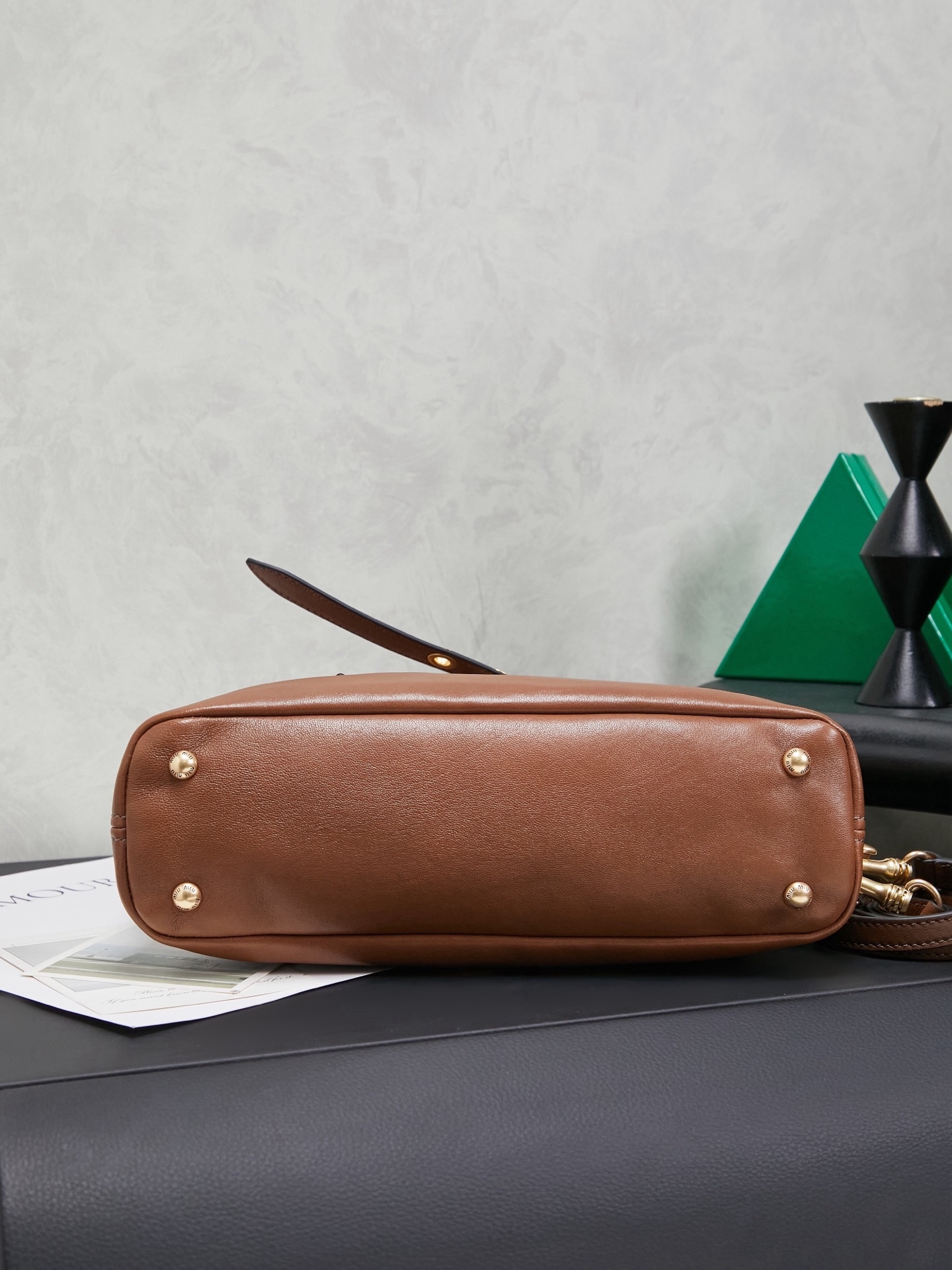 Aventure包袋展现出简约随性的魅力。重新诠释经典线条，这款柔软的Nappa变体展现出多功能和实用的态度，并通过精致独特的细节得到提升。aventure nappa皮革手袋灵感源自miu典藏设计，结构经过调整，变得更加轻便，焕发全新个性，饰以压花字母徽标，增添标志性元素，复古金色五金配件，亚麻混纺衬里，配拉链口袋和贴袋，长手腕适合用作手提或单肩
