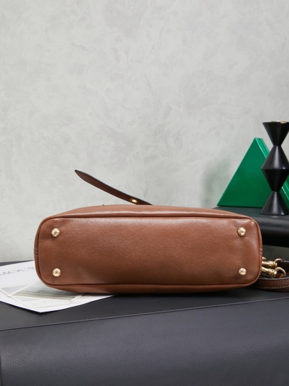 Aventure包袋展现出简约随性的魅力。重新诠释经典线条，这款柔软的Nappa变体展现出多功能和实用的态度，并通过精致独特的细节得到提升。aventure nappa皮革手袋灵感源自miu典藏设计，结构经过调整，变得更加轻便，焕发全新个性，饰以压花字母徽标，增添标志性元素，复古金色五金配件，亚麻混纺衬里，配拉链口袋和贴袋，长手腕适合用作手提或单肩
